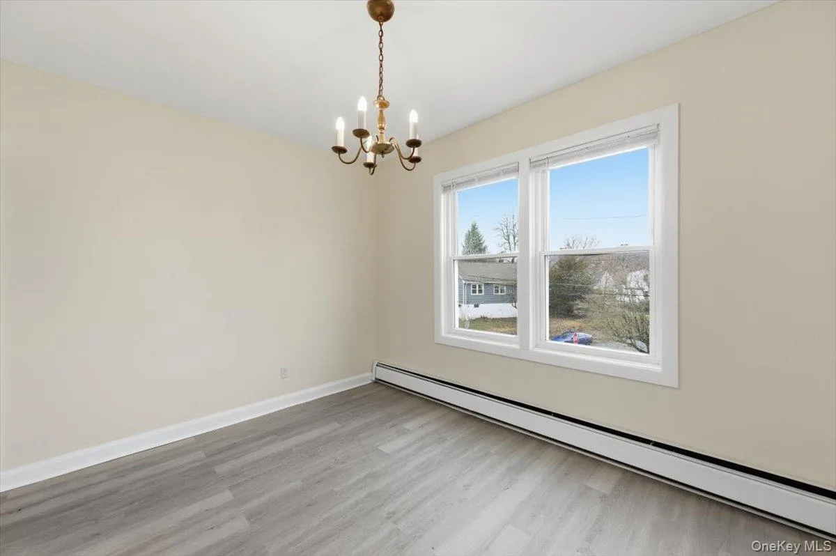 Dining Room featuring a baseboard heating unit, hanging lights, and light wood-style flooring Dining Room featuring a baseboard heating unit, hanging lights, and light wood-style flooring