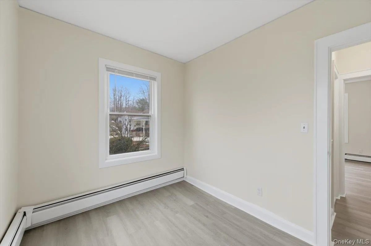 Empty room featuring a baseboard heating unit and light wood-type flooring Empty room featuring a baseboard heating unit and light wood-type flooring