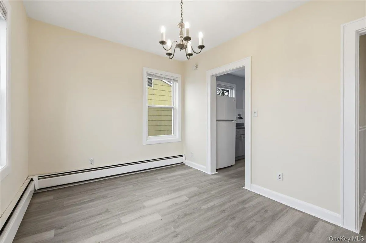 Dining area featuring hanging lights, baseboard heating, and light wood-style floors Dining area featuring hanging lights, baseboard heating, and light wood-style floors