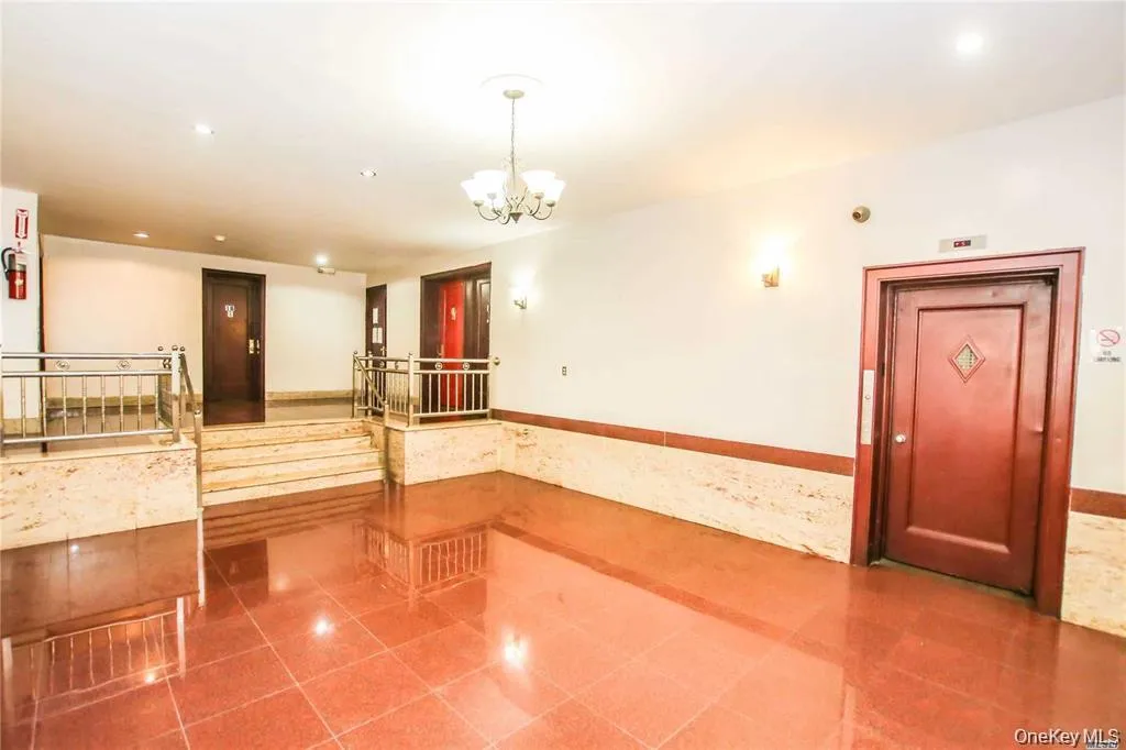 Tiled empty room with recessed lighting, a wainscoted wall, a chandelier, and tile walls Tiled empty room with recessed lighting, a wainscoted wall, a chandelier, and tile walls