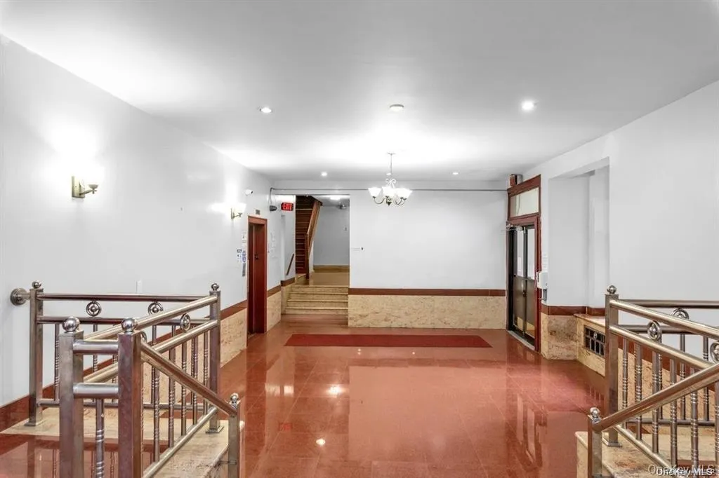 Hallway featuring a chandelier, stairs, recessed lighting, and an upstairs landing Hallway featuring a chandelier, stairs, recessed lighting, and an upstairs landing