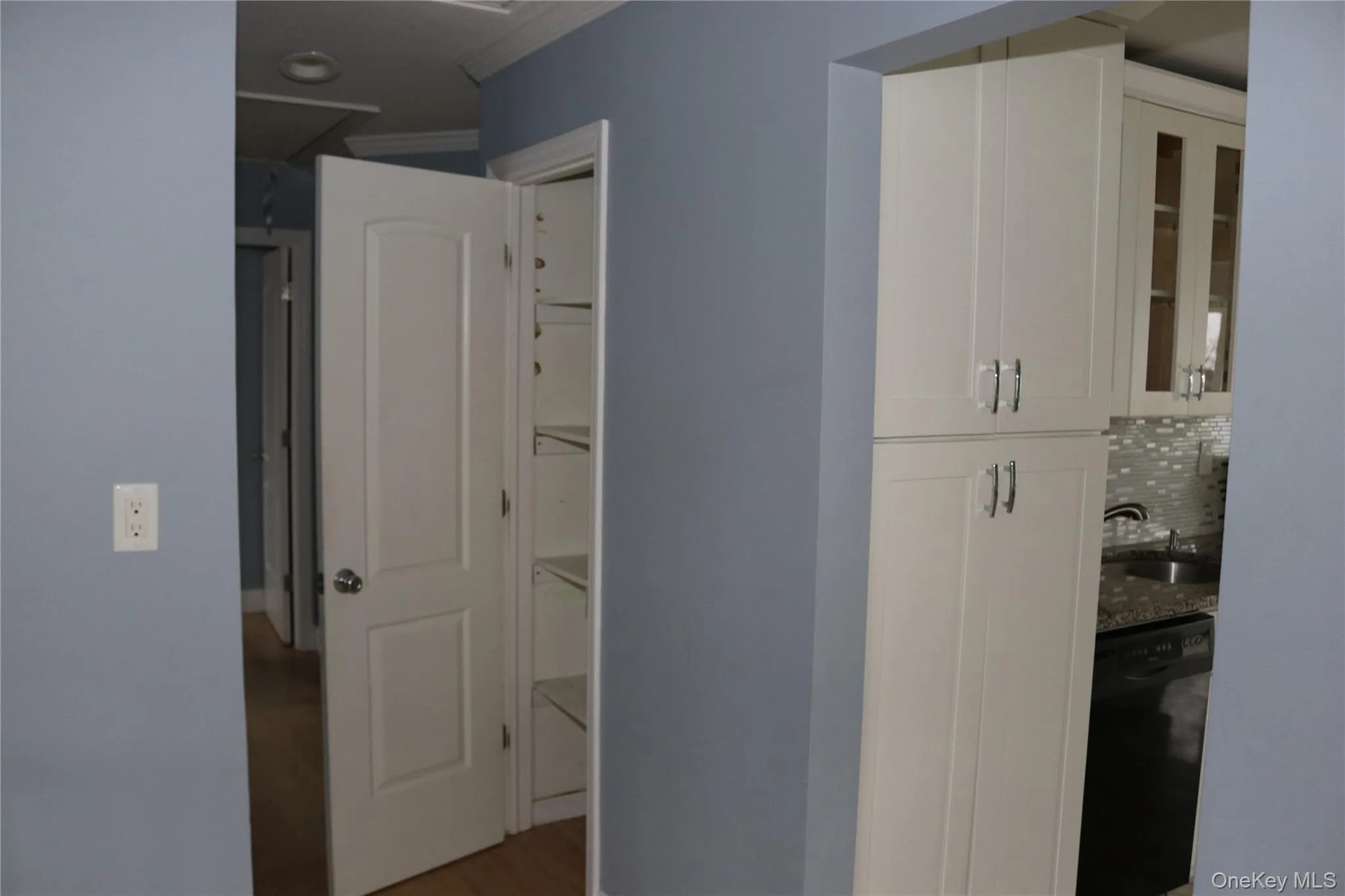 Hallway with ornamental molding and wood finished floors Hallway with ornamental molding and wood finished floors