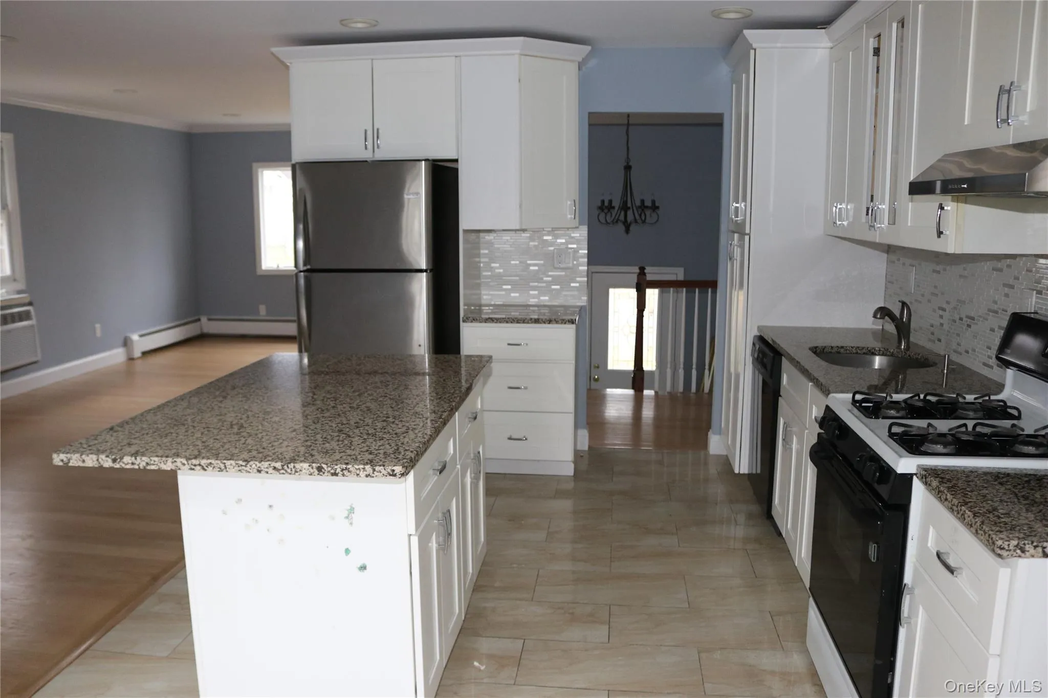 Kitchen with gas range, backsplash, dark stone counters, recessed lighting, and ornamental molding Kitchen with gas range, backsplash, dark stone counters, recessed lighting, and ornamental molding