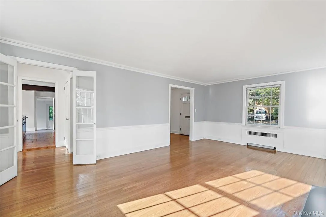 Sun-filled living room with French doors and hardwood floors Sun-filled living room with French doors and hardwood floors