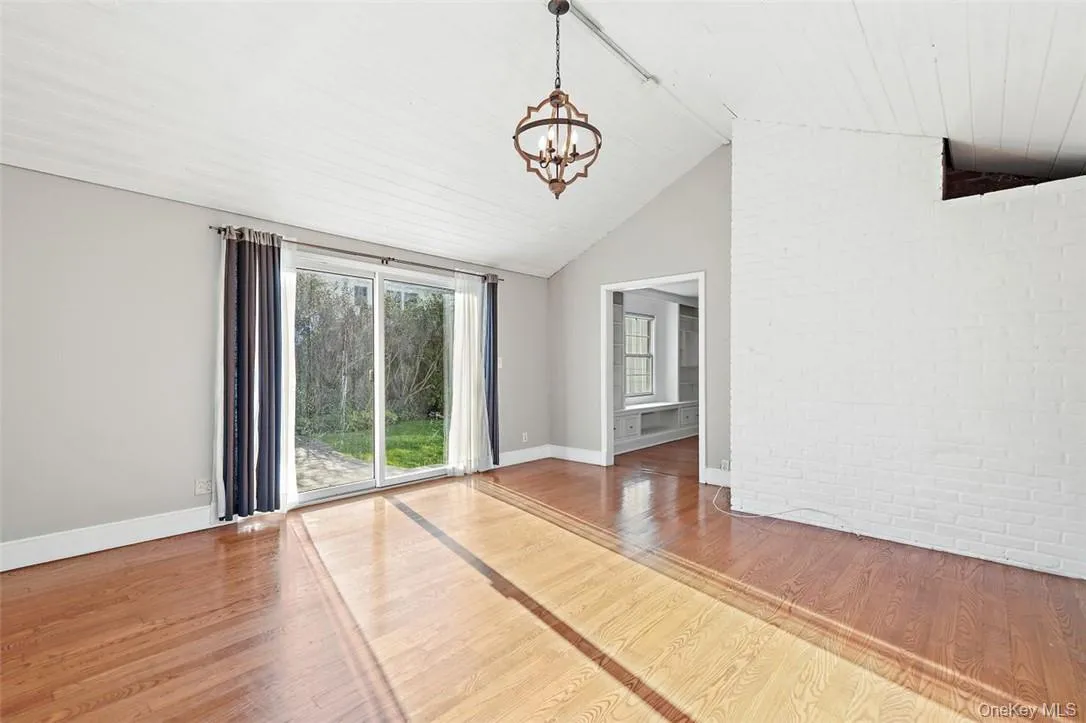 Spacious family room with lofted ceiling and hardwood floors Spacious family room with lofted ceiling and hardwood floors