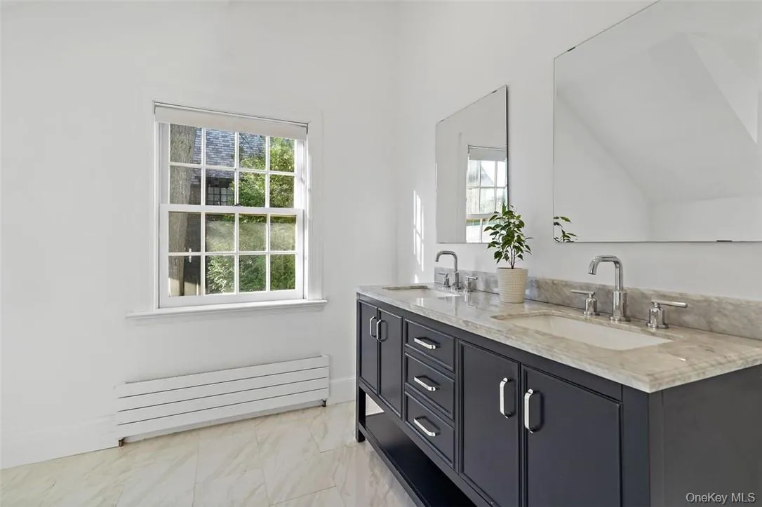 Primary bathroom with dual sinks, vaulted ceiling and plenty of natural light Primary bathroom with dual sinks, vaulted ceiling and plenty of natural light