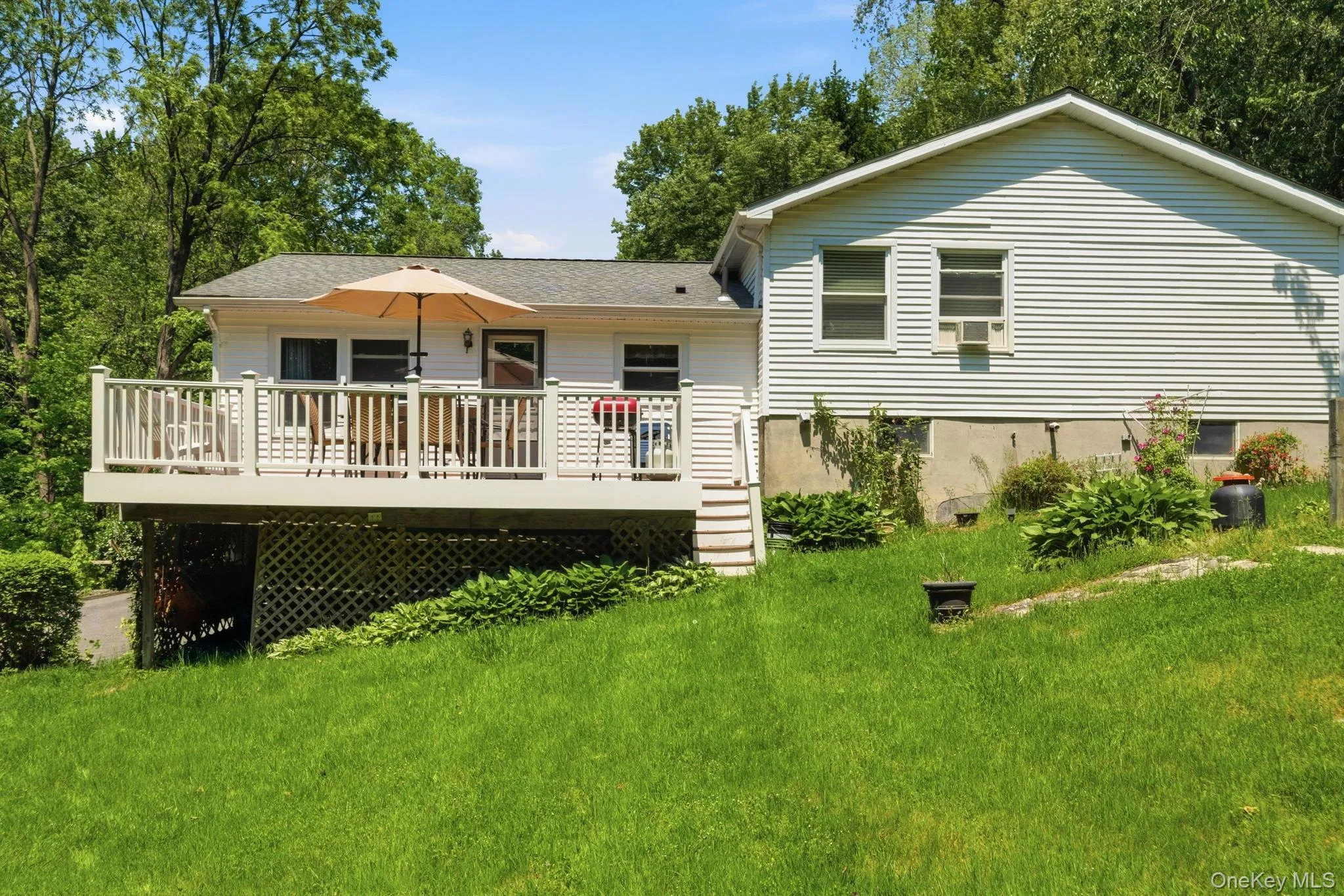 A closer look at the rear exterior shows the elevated deck and the home's setting against a backdrop of mature woods. A closer look at the rear exterior shows the elevated deck and the home's setting against a backdrop of mature woods.