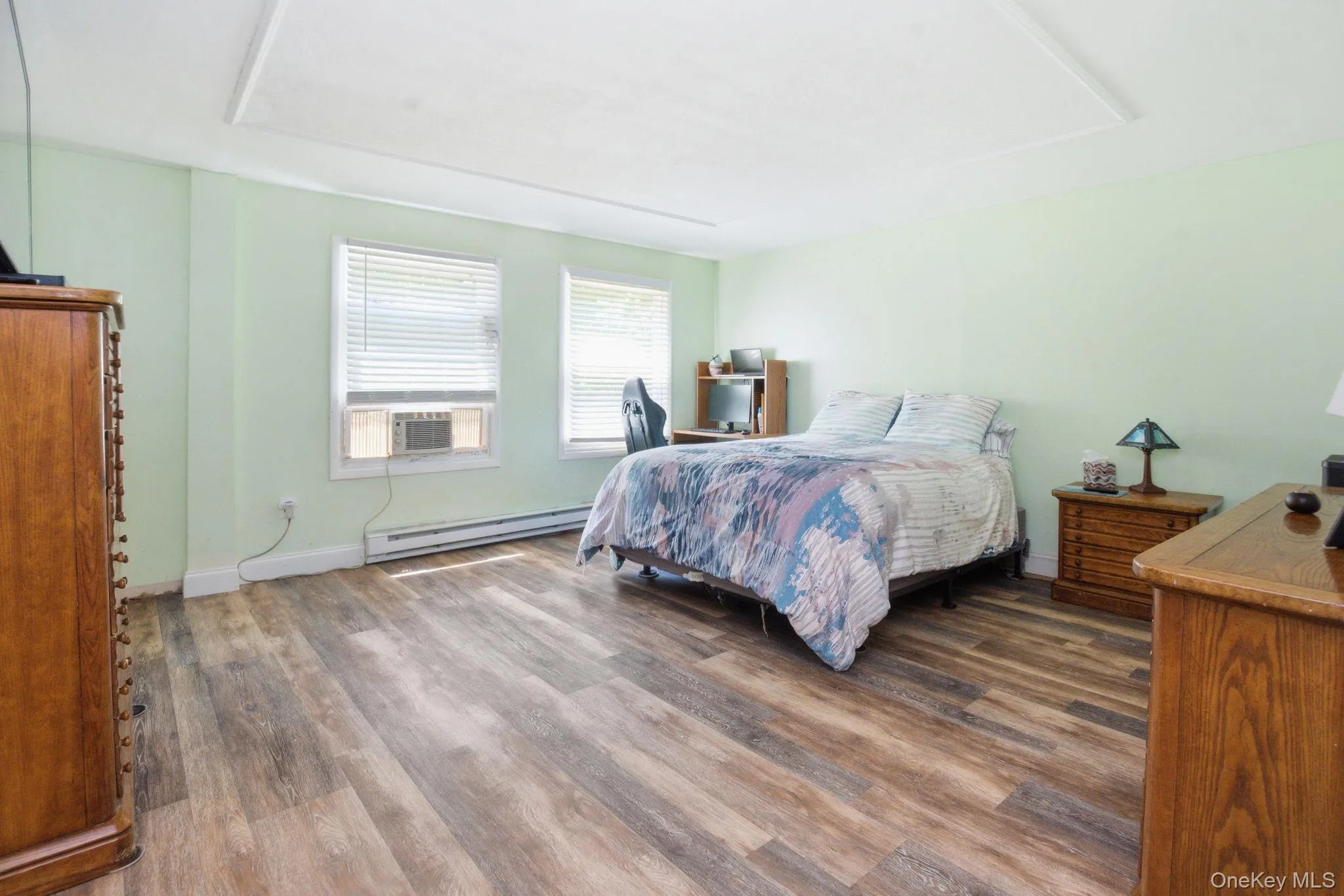 The spacious primary bedroom features updated vinyl plank flooring, dual windows, and room to spread out. The spacious primary bedroom features updated vinyl plank flooring, dual windows, and room to spread out.