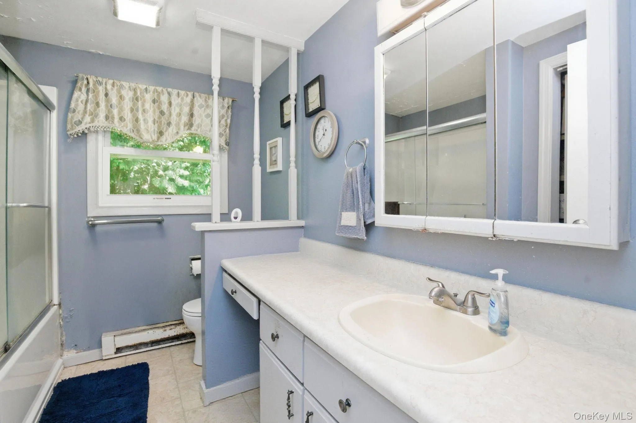 The full hall bath includes a single vanity, a wide mirrored medicine cabinet, and a window that keeps the space bright. The full hall bath includes a single vanity, a wide mirrored medicine cabinet, and a window that keeps the space bright.