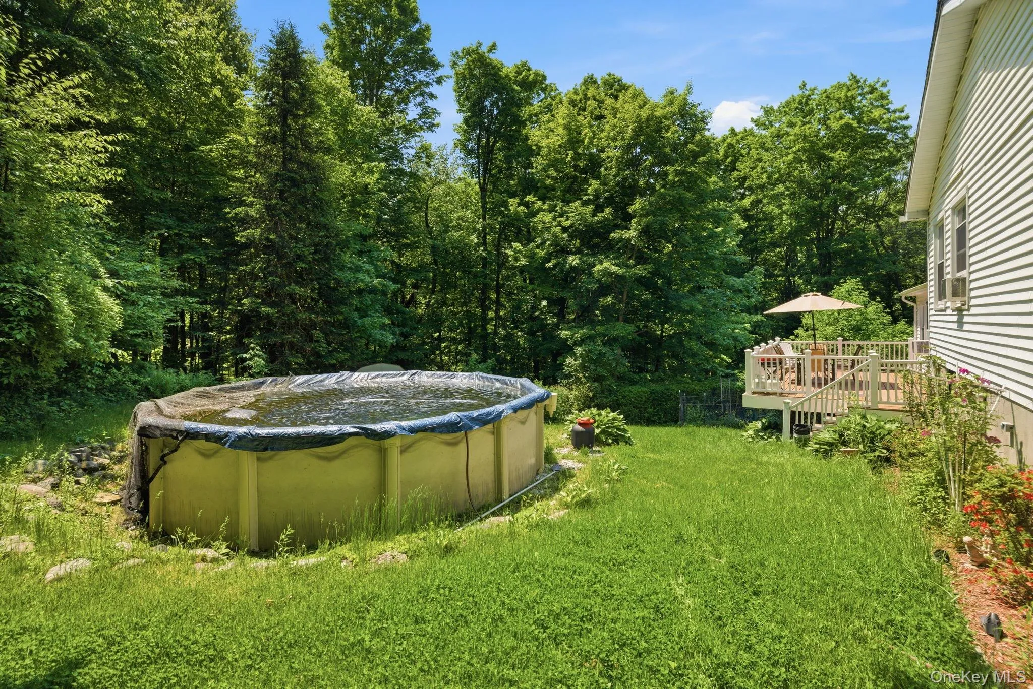 An above-ground pool sits just steps from the deck, with the tree line wrapping the yard for a quiet, tucked-away feel. An above-ground pool sits just steps from the deck, with the tree line wrapping the yard for a quiet, tucked-away feel.