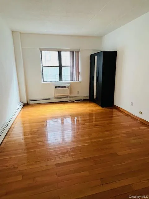 Bedroom with a baseboard radiator and light wood-type flooring Bedroom with a baseboard radiator and light wood-type flooring