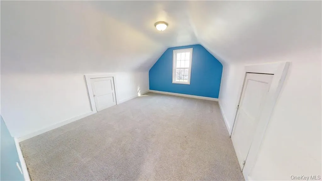 Additional living space featuring lofted ceiling and carpet Additional living space featuring lofted ceiling and carpet