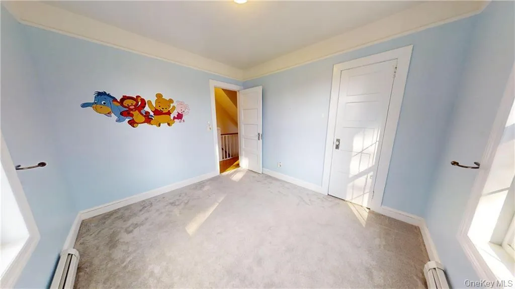 Unfurnished bedroom with carpet, a baseboard heating unit, and a baseboard radiator Unfurnished bedroom with carpet, a baseboard heating unit, and a baseboard radiator