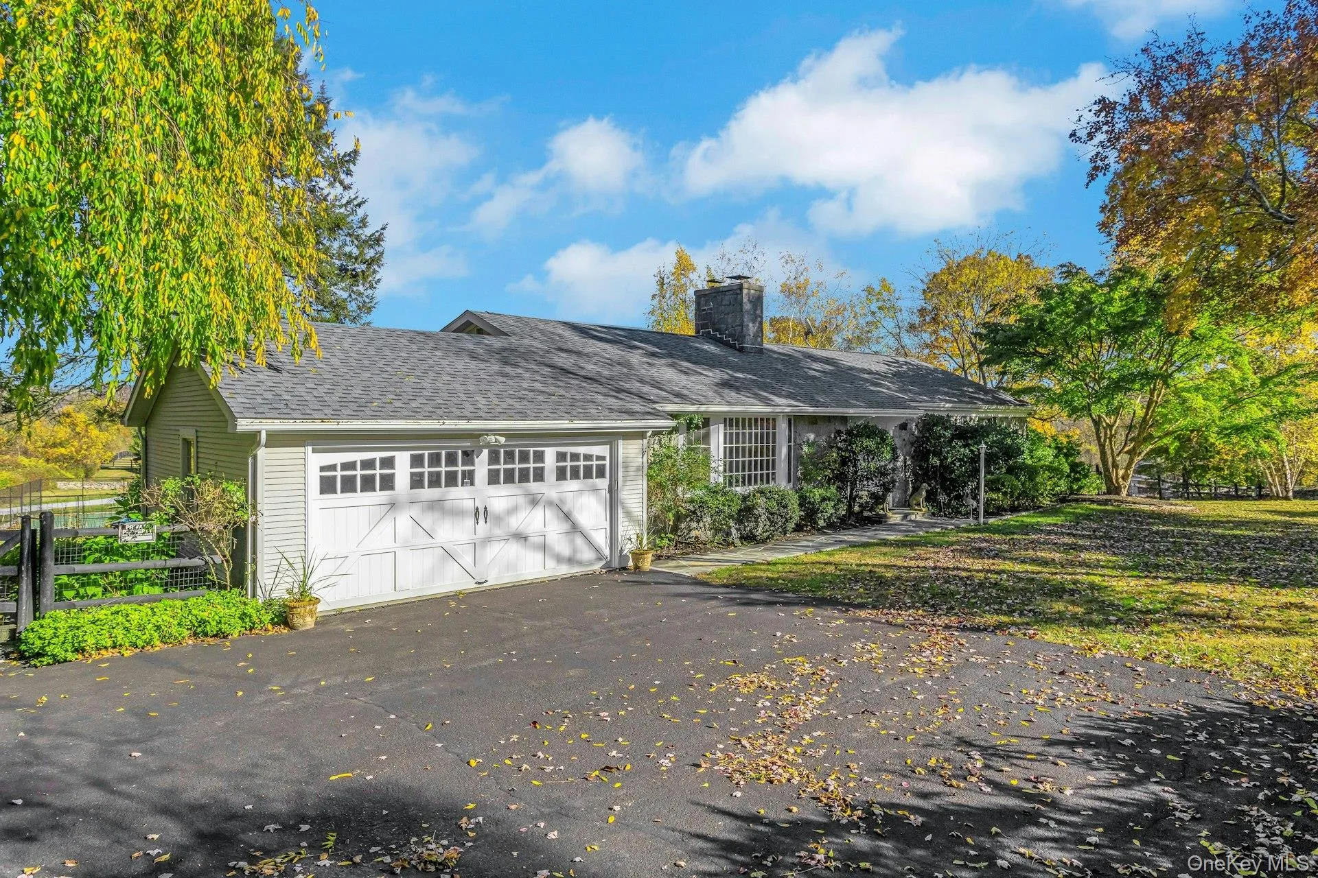 View of front of home featuring asphalt driveway, a chimney, a garage, and a shingled roof View of front of home featuring asphalt driveway, a chimney, a garage, and a shingled roof