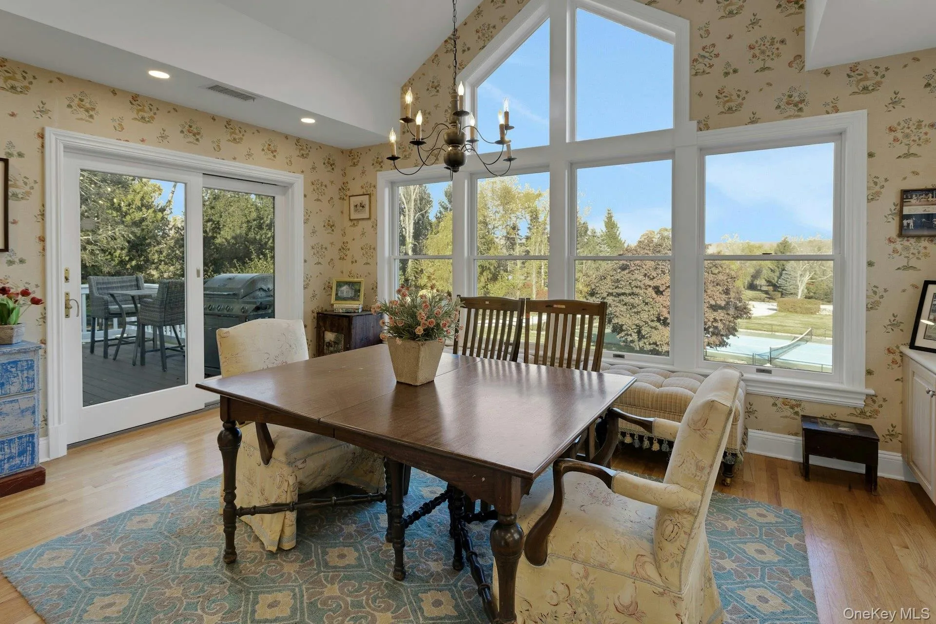 Dining area with wallpapered walls, plenty of natural light, light wood-style floors, a chandelier, and recessed lighting Dining area with wallpapered walls, plenty of natural light, light wood-style floors, a chandelier, and recessed lighting