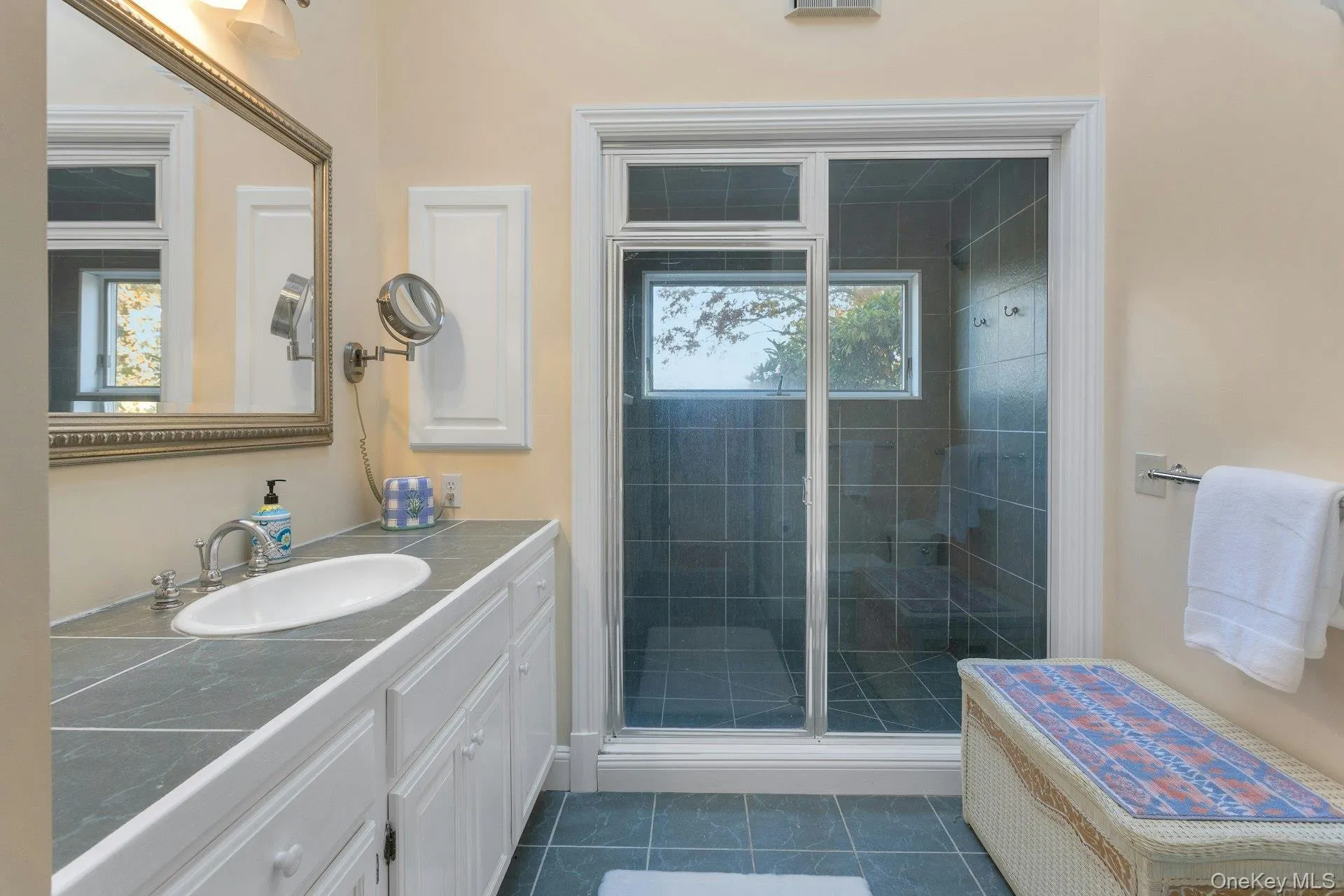 Full bath with vanity, dark tile patterned flooring, and a shower stall Full bath with vanity, dark tile patterned flooring, and a shower stall
