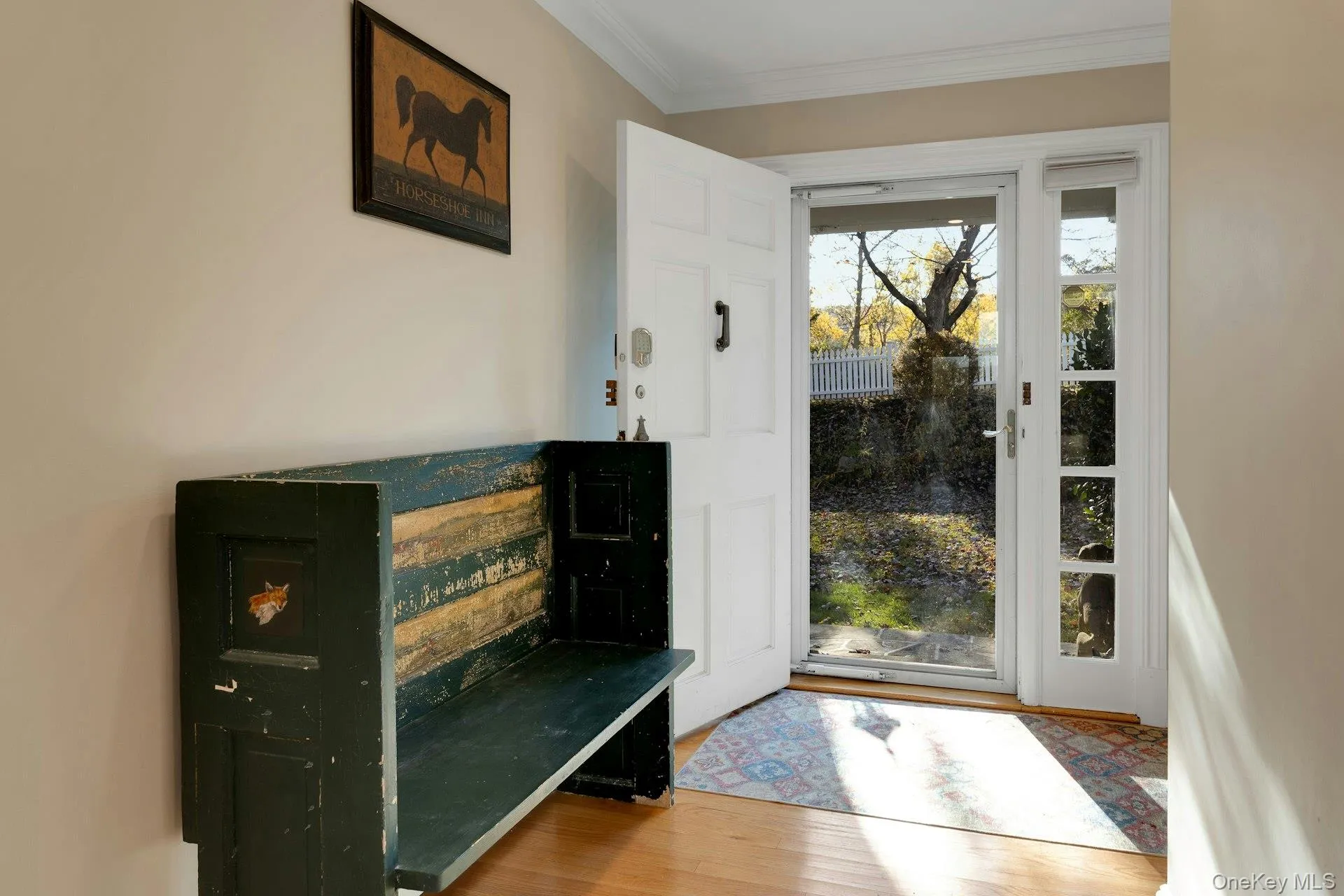 Doorway featuring crown molding and wood finished floors Doorway featuring crown molding and wood finished floors
