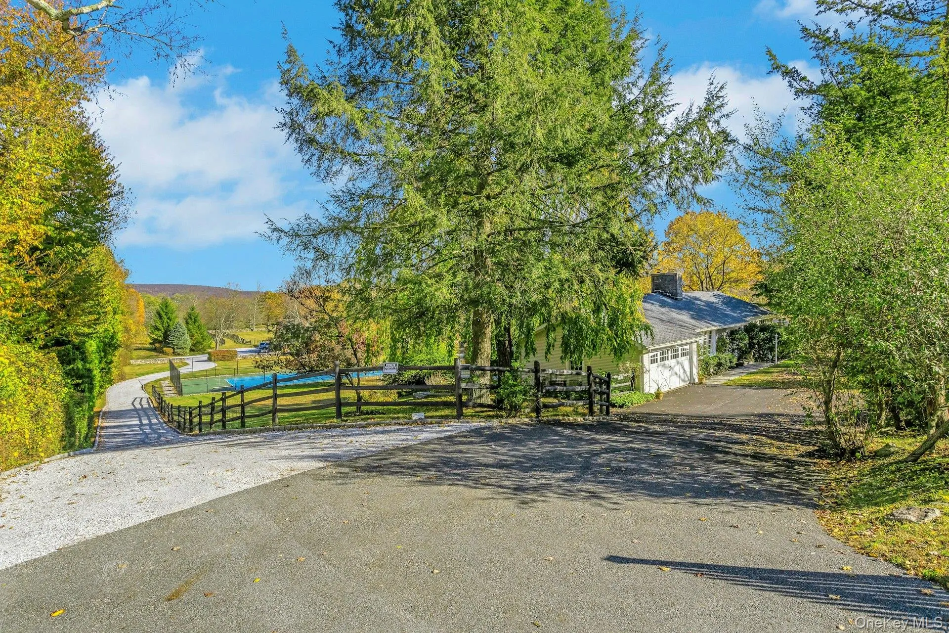 View of asphalt driveway with a gate View of asphalt driveway with a gate