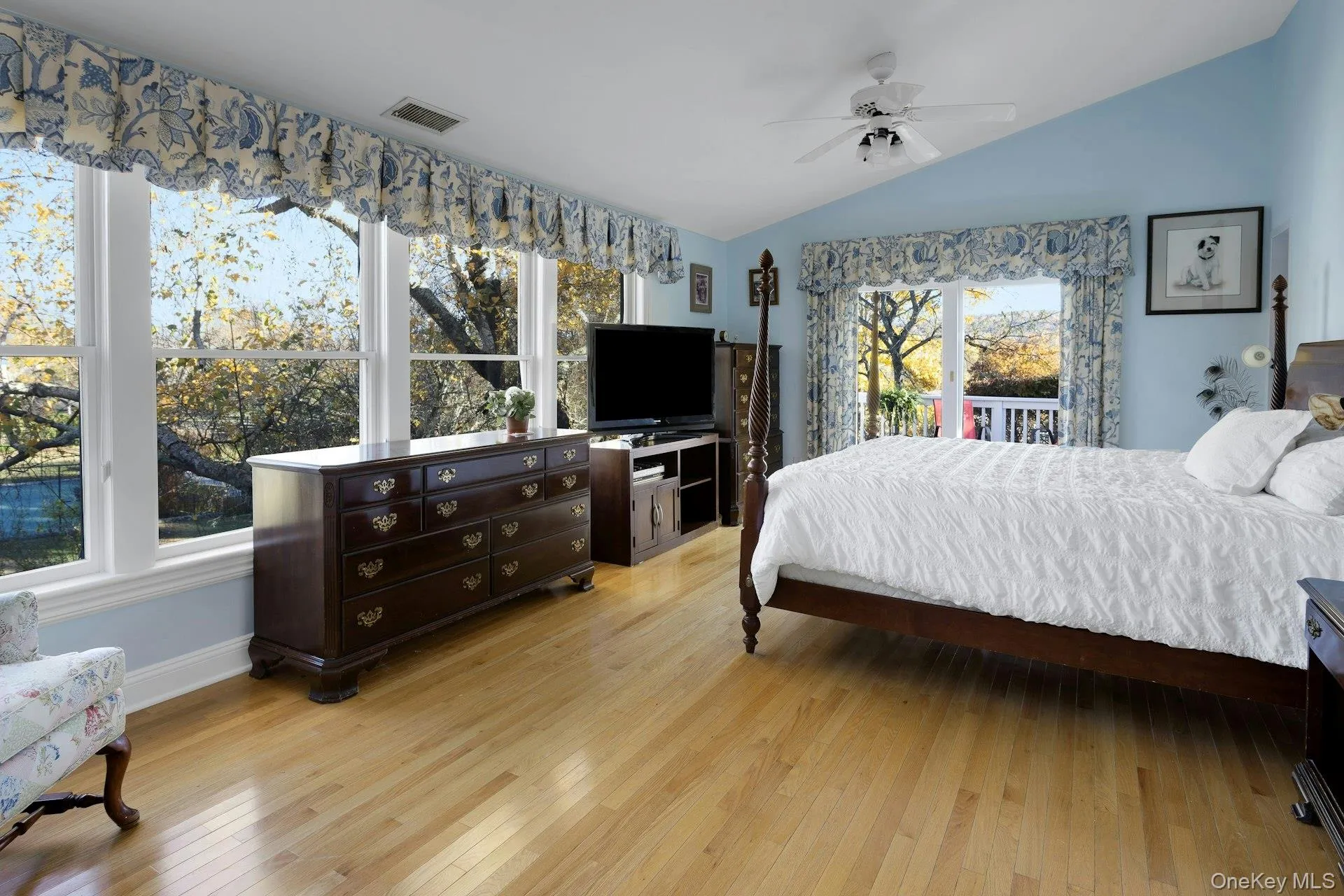 Bedroom featuring vaulted ceiling, light wood finished floors, access to exterior, and ceiling fan Bedroom featuring vaulted ceiling, light wood finished floors, access to exterior, and ceiling fan