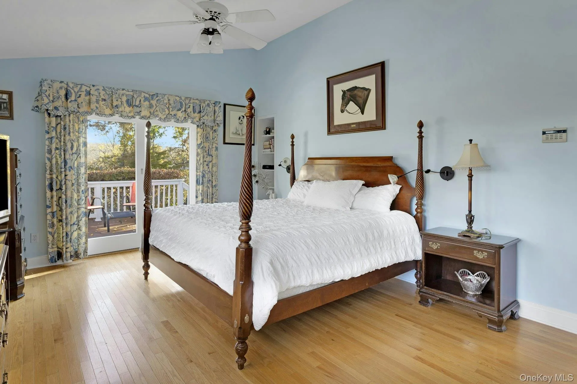 Bedroom with lofted ceiling, access to outside, light wood finished floors, and a ceiling fan Bedroom with lofted ceiling, access to outside, light wood finished floors, and a ceiling fan