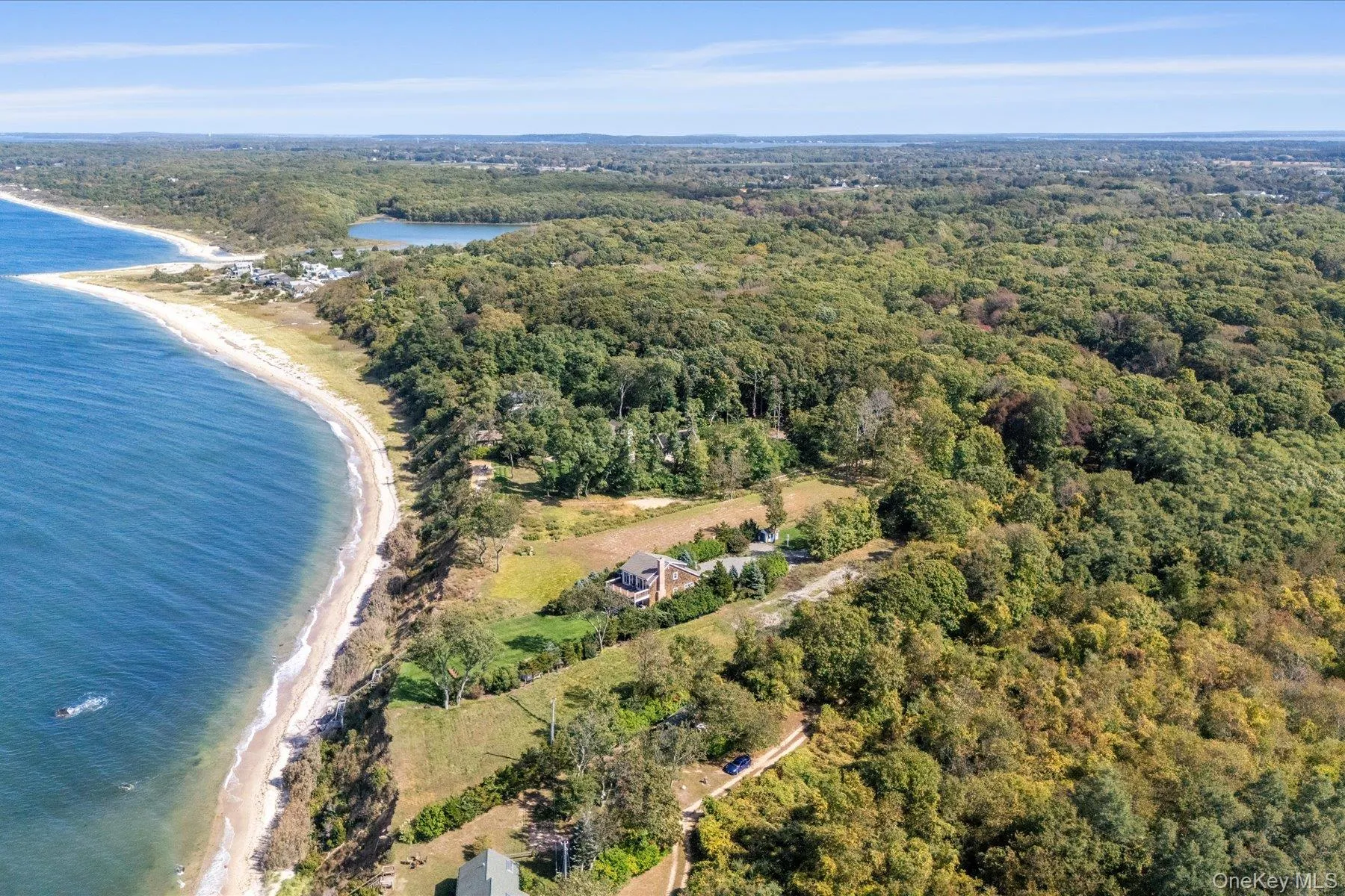 Spectacular aerial showcasing the property's location along the North Fork coastline, with sweeping shoreline views, expansive woodlands, and open-water scenery stretching for miles. Spectacular aerial showcasing the property's location along the North Fork coastline, with sweeping shoreline views, expansive woodlands, and open-water scenery stretching for miles.