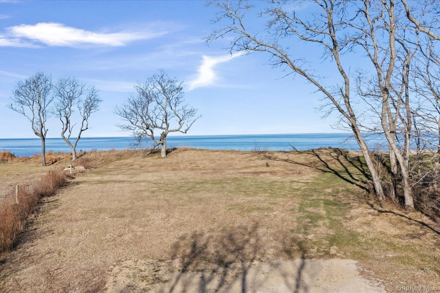 Open bluff-top clearing with sweeping water views and a serene natural backdrop, offering an exceptional setting along the shoreline Open bluff-top clearing with sweeping water views and a serene natural backdrop, offering an exceptional setting along the shoreline