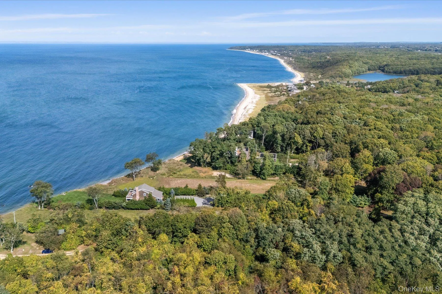 Breathtaking aerial capturing the North Fork coastline with sweeping open-water views, sandy shoreline, and scenic natural surroundings stretching into the distance. Breathtaking aerial capturing the North Fork coastline with sweeping open-water views, sandy shoreline, and scenic natural surroundings stretching into the distance.