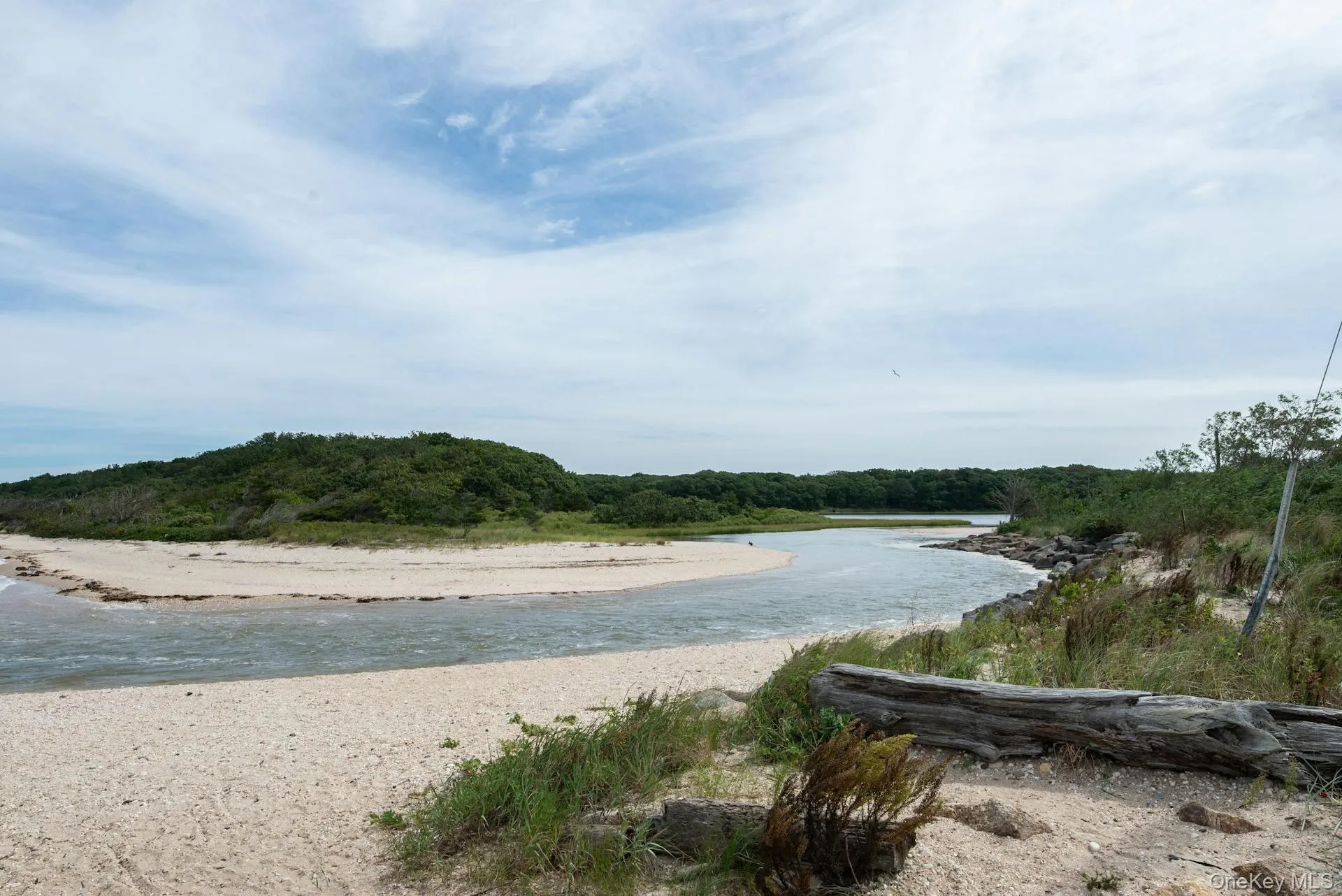 Tranquil coastal inlet with sandy shoreline and natural dune landscape, showcasing the area's unspoiled waterfront beauty and serene surroundings Tranquil coastal inlet with sandy shoreline and natural dune landscape, showcasing the area's unspoiled waterfront beauty and serene surroundings