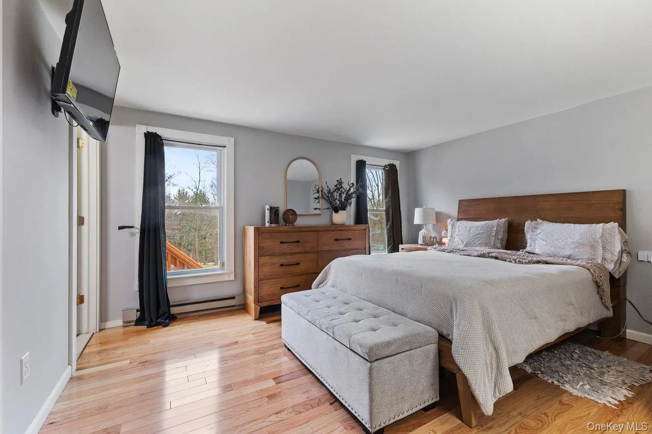 Large primary bedroom with new hardwood floors. Large primary bedroom with new hardwood floors.