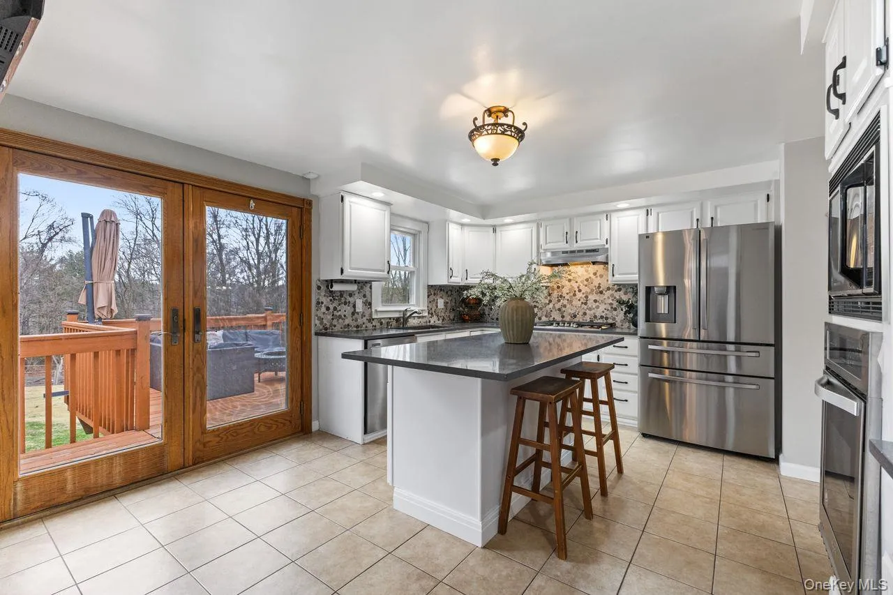 French doors in kitchen leading to large deck overlooking yard. French doors in kitchen leading to large deck overlooking yard.