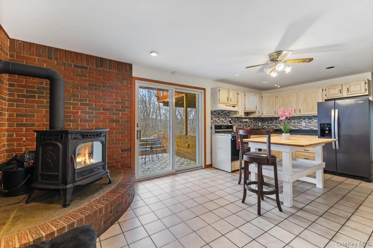 Lower level in law suite with pellet stove and sliding glass doors to yard. Lower level in law suite with pellet stove and sliding glass doors to yard.