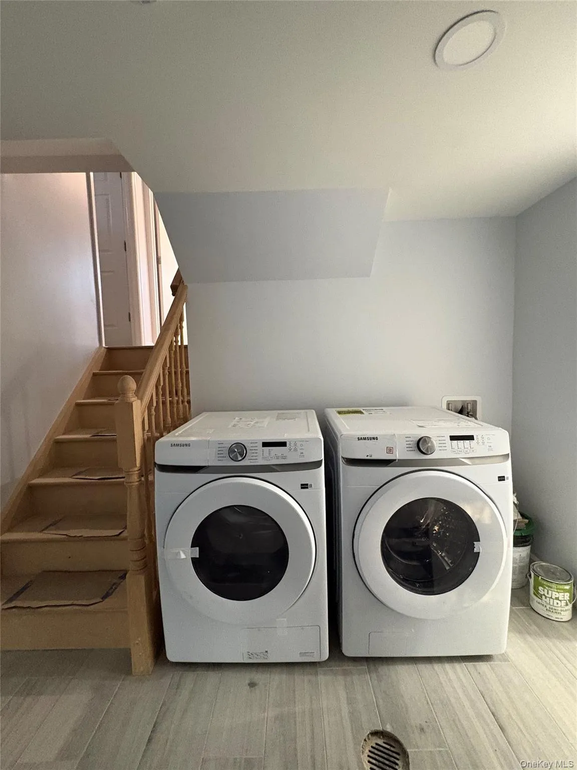 Laundry area with light wood-style flooring and independent washer and dryer Laundry area with light wood-style flooring and independent washer and dryer
