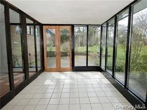 Enjoy the airy sunroom with walls of glass overlooking the back patio Enjoy the airy sunroom with walls of glass overlooking the back patio