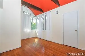 One room upstairs with vaulted ceiling with beams and tall wooden accordion door separating second room One room upstairs with vaulted ceiling with beams and tall wooden accordion door separating second room
