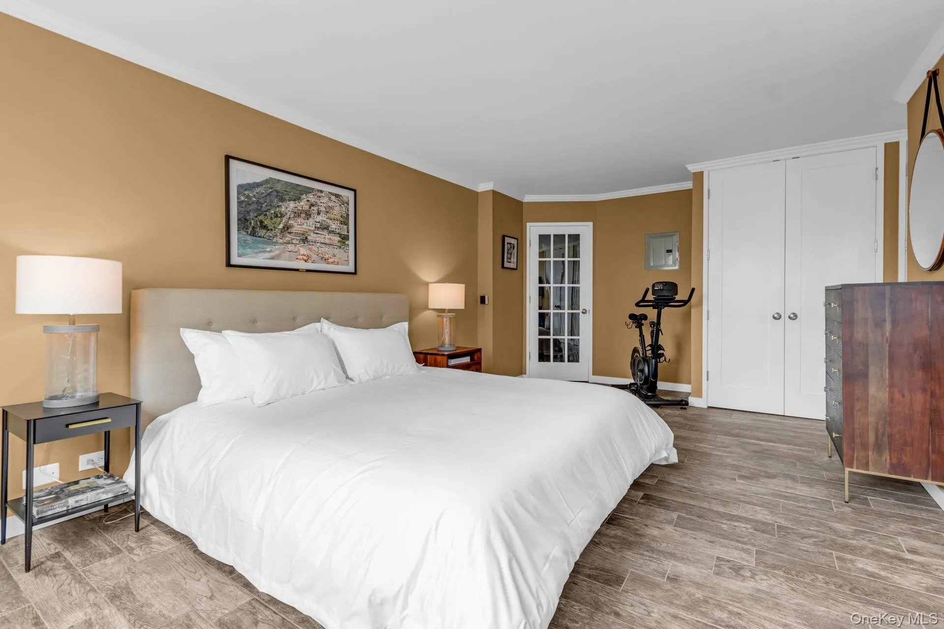 Bedroom with ornamental molding, wood finished floors, and a closet Bedroom with ornamental molding, wood finished floors, and a closet