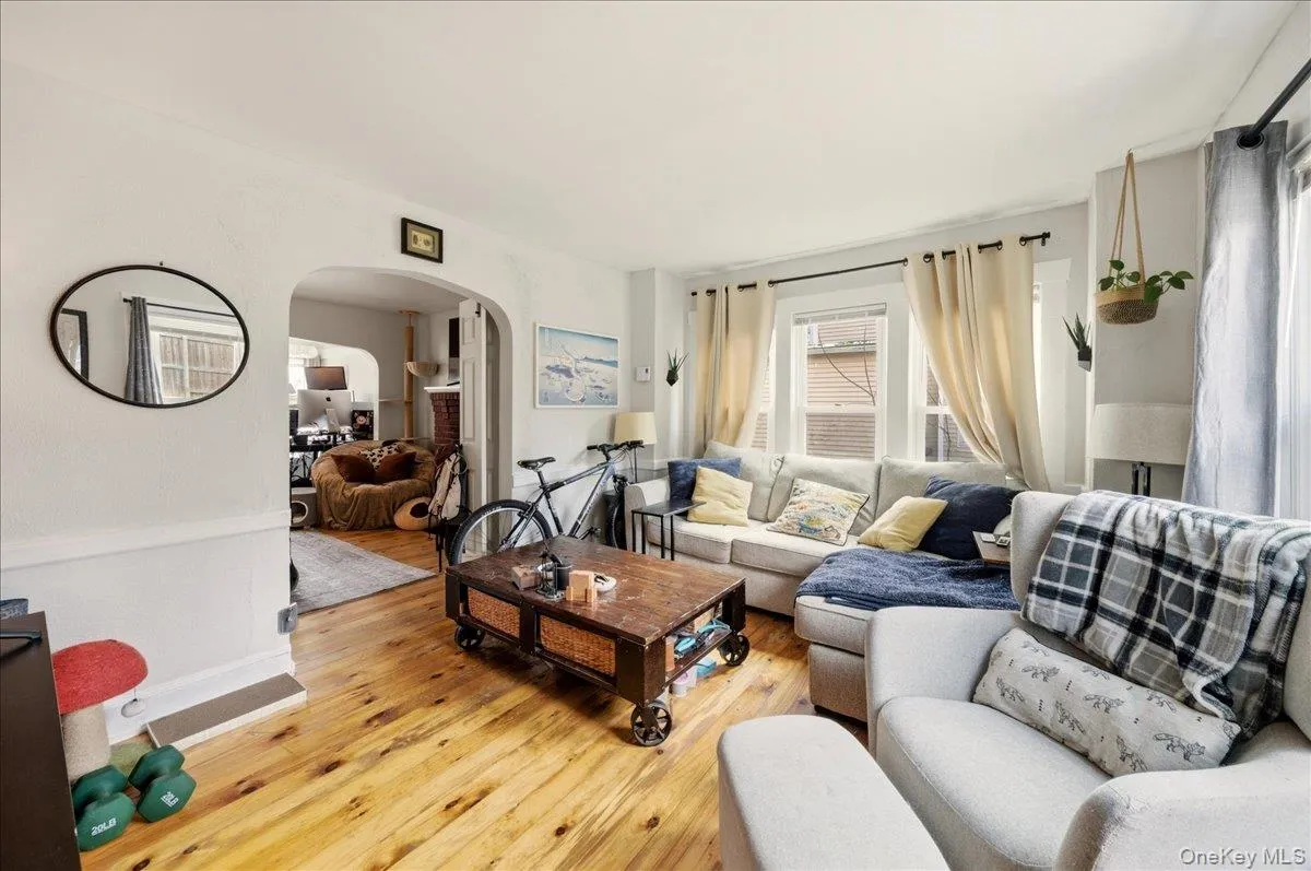 Living area with light wood finished floors and arched walkways Living area with light wood finished floors and arched walkways