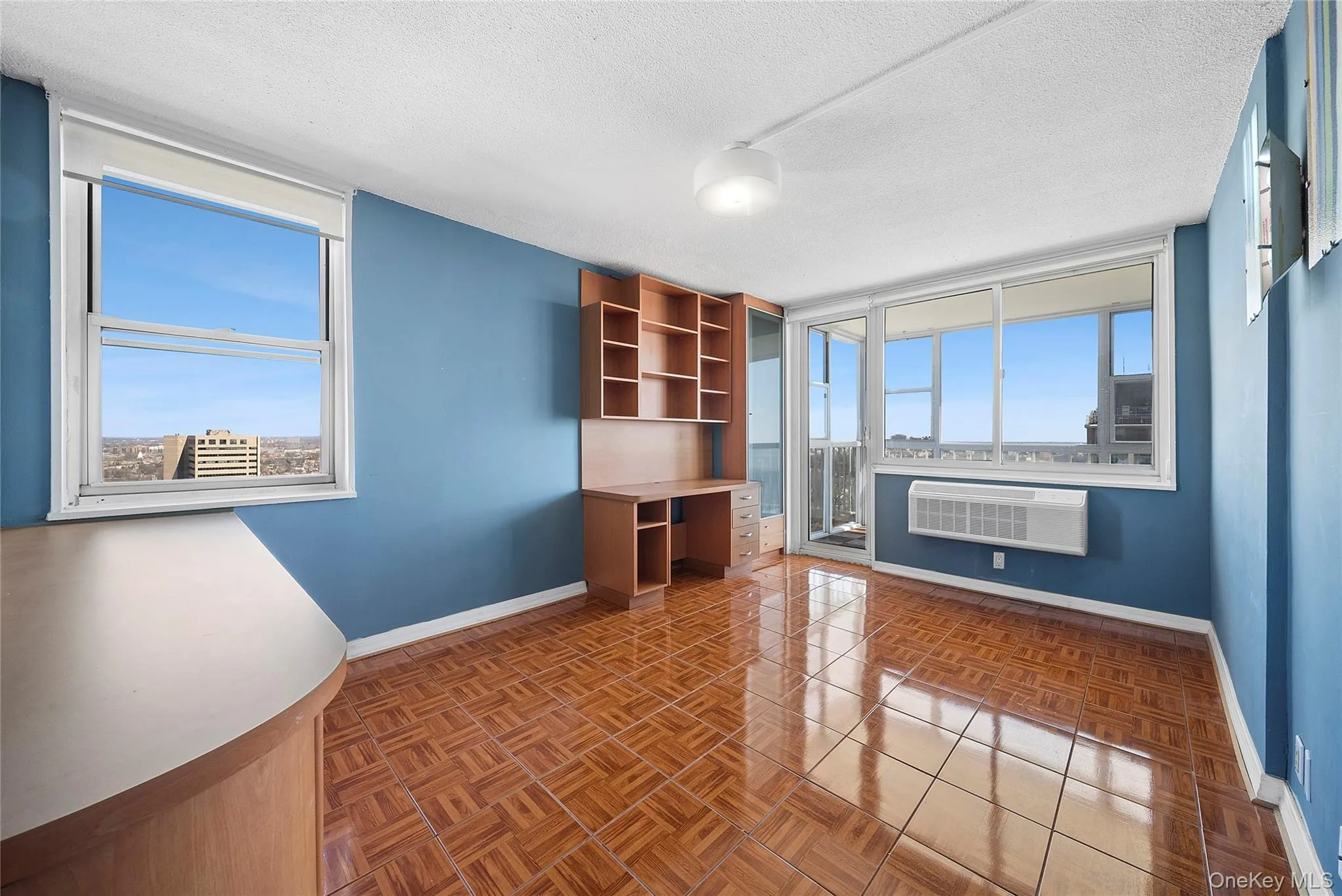 Unfurnished office featuring a textured ceiling, built in study area, and parquet floors Unfurnished office featuring a textured ceiling, built in study area, and parquet floors
