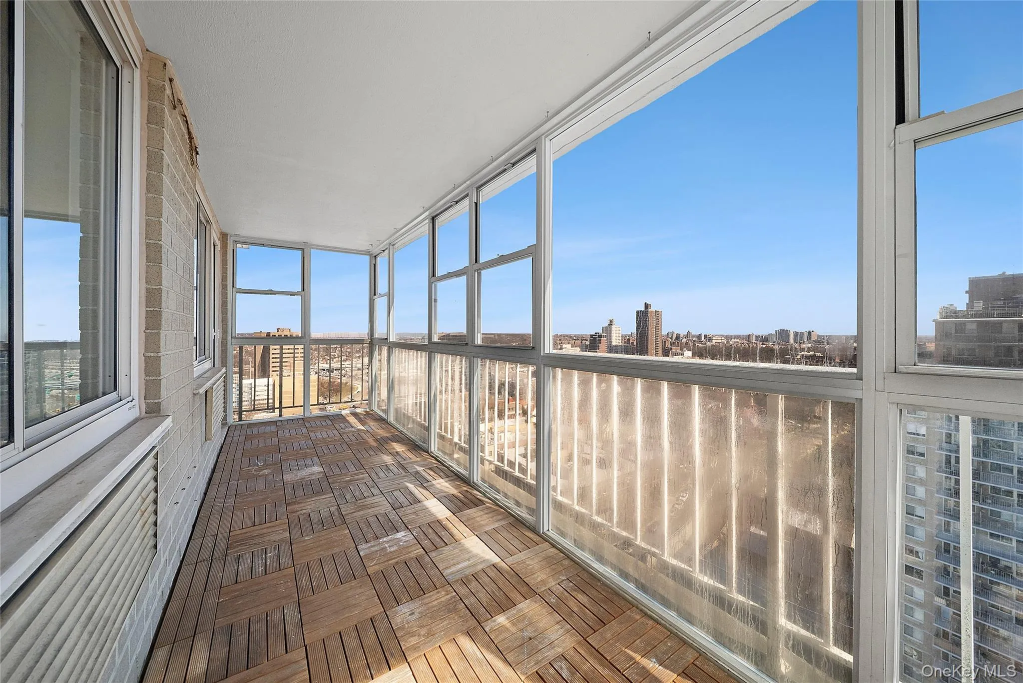 Balcony with a city view, parquet floors, and expansive windows Balcony with a city view, parquet floors, and expansive windows
