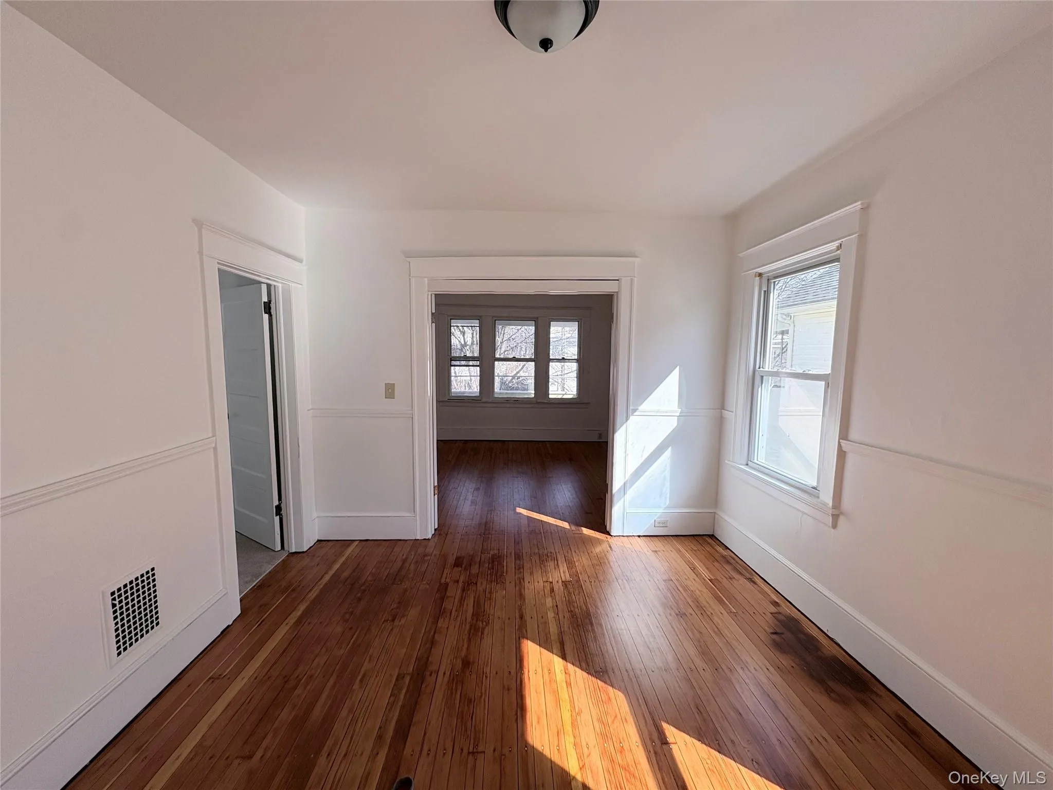 Living room with hardwood flooring and craftsman molding and baseboards Living room with hardwood flooring and craftsman molding and baseboards