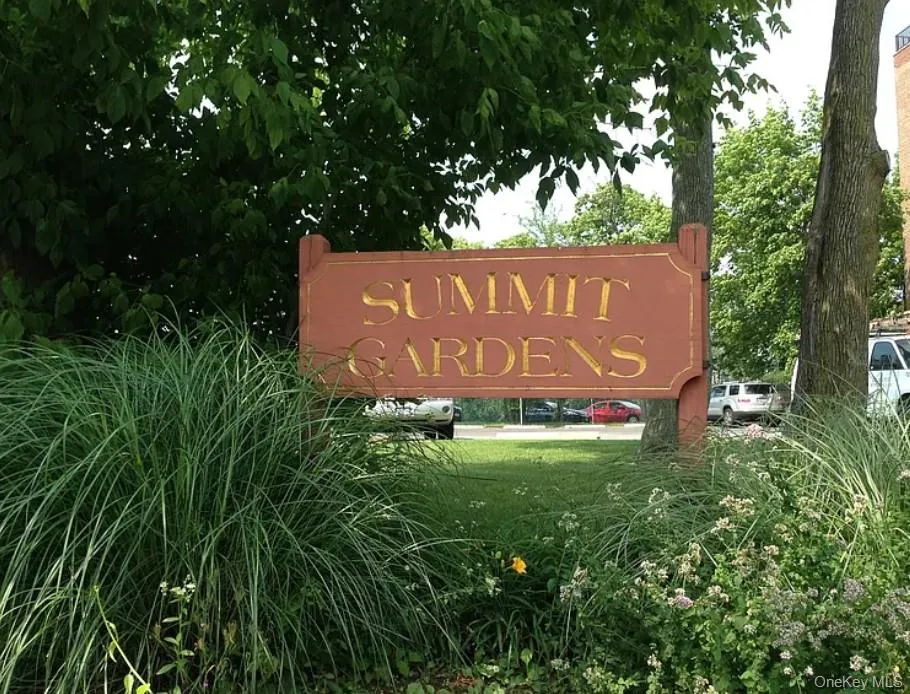 Community sign featuring a lawn Community sign featuring a lawn