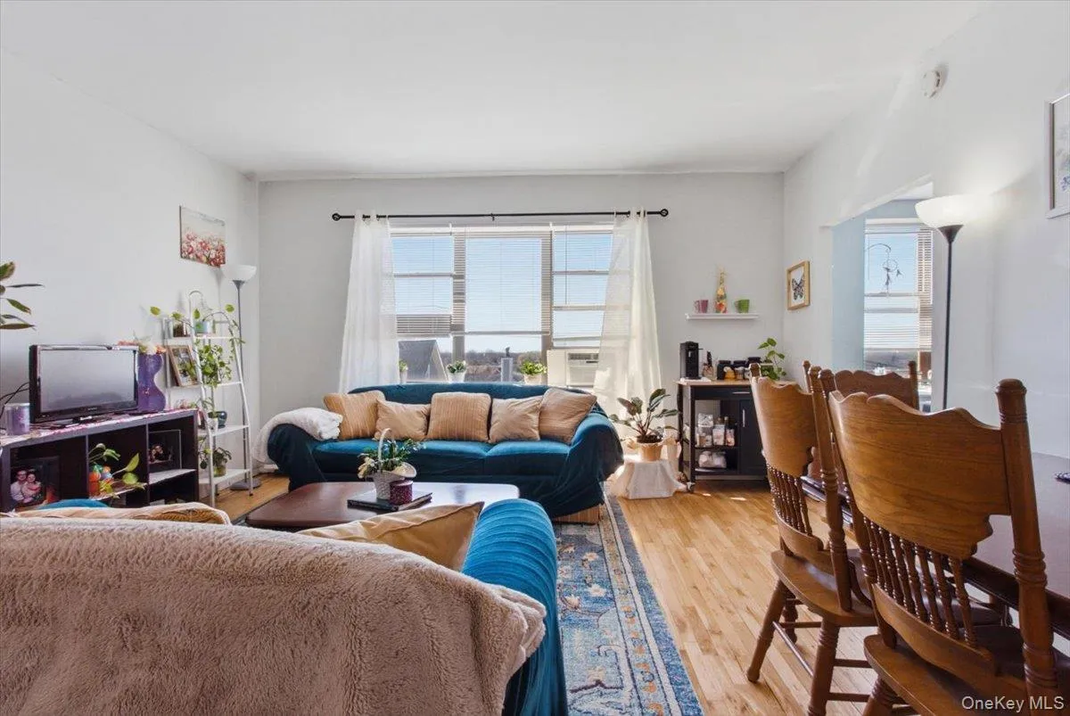 Living room with light wood-style flooring, plenty of natural light, and cooling unit Living room with light wood-style flooring, plenty of natural light, and cooling unit