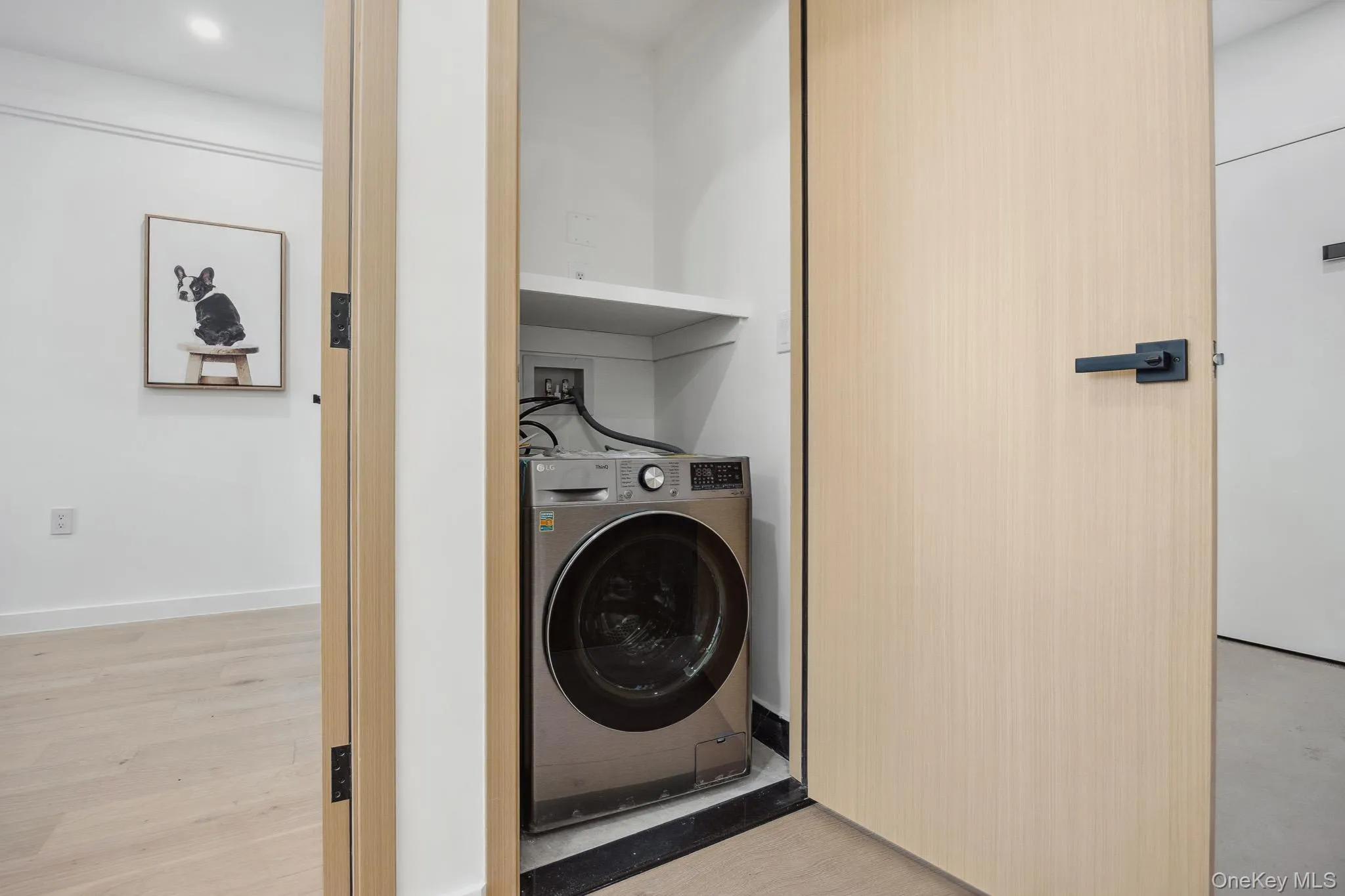 Washroom featuring washer / clothes dryer and light wood-style flooring Washroom featuring washer / clothes dryer and light wood-style flooring