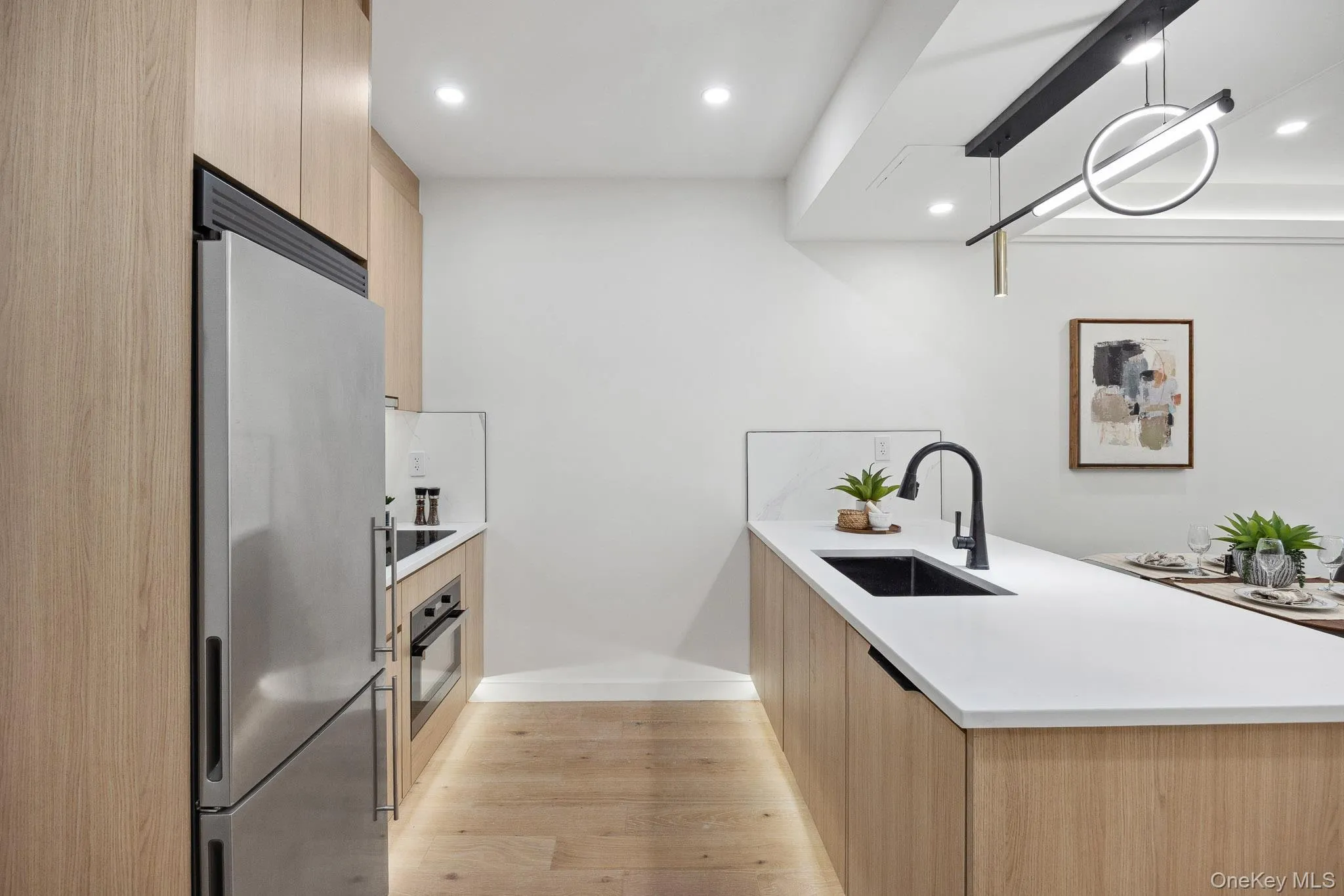 Kitchen featuring stainless steel appliances, modern cabinets, light brown cabinets, a sink, and recessed lighting Kitchen featuring stainless steel appliances, modern cabinets, light brown cabinets, a sink, and recessed lighting