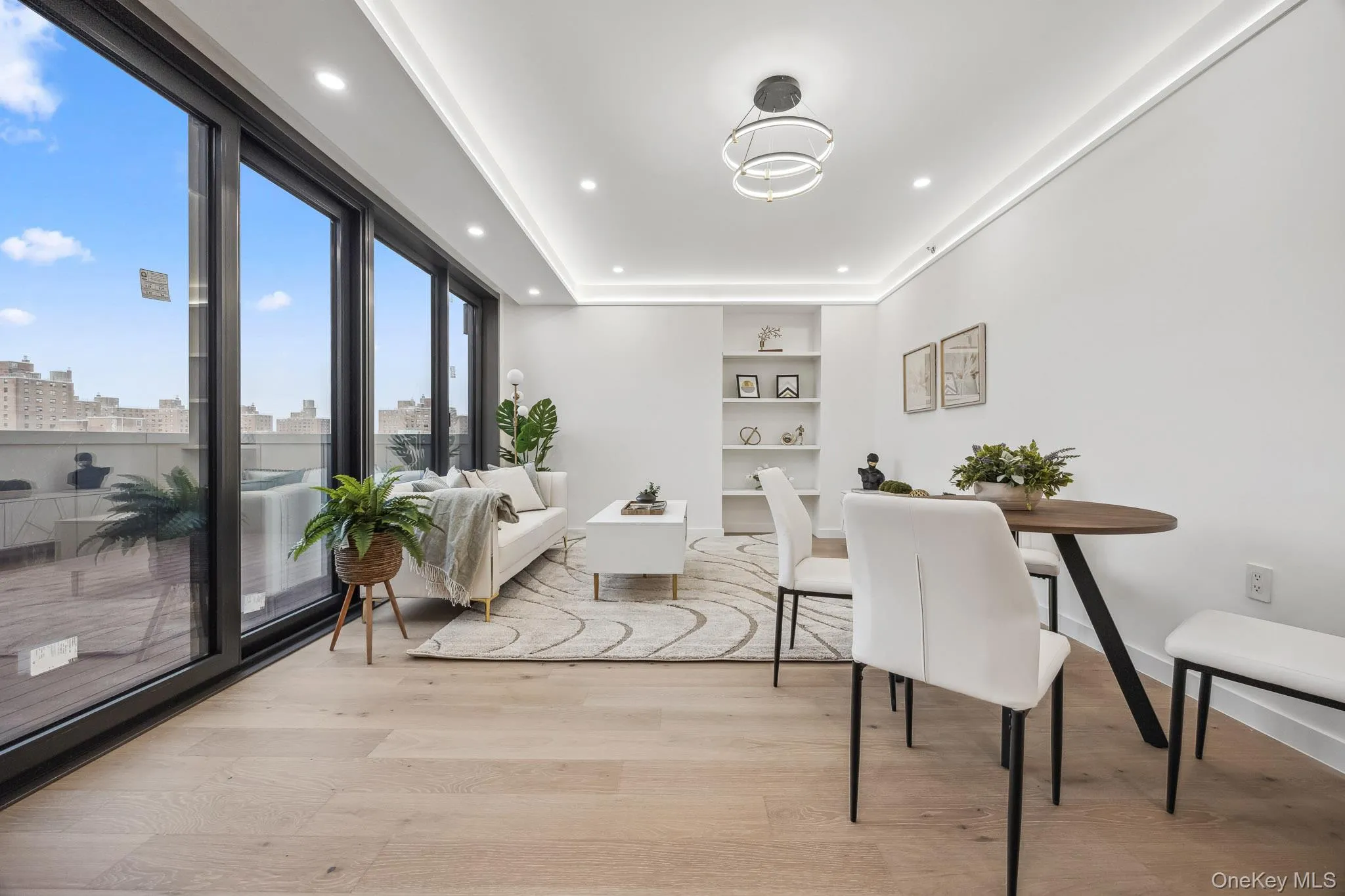 Dining area with built in shelves, light wood-type flooring, baseboards, recessed lighting, and a view of city Dining area with built in shelves, light wood-type flooring, baseboards, recessed lighting, and a view of city