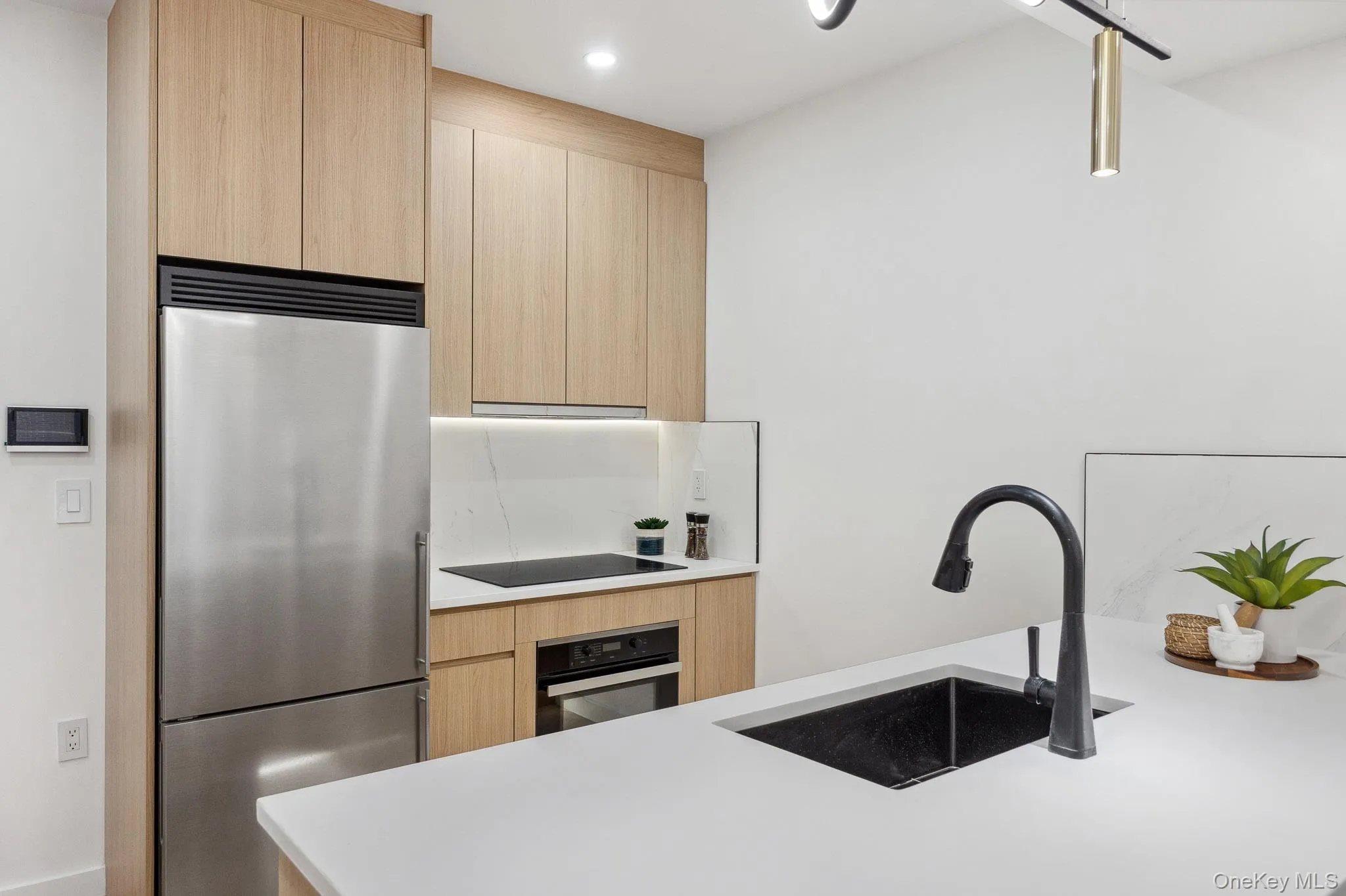 Kitchen featuring high end fridge, wall oven, light brown cabinets, a sink, and recessed lighting Kitchen featuring high end fridge, wall oven, light brown cabinets, a sink, and recessed lighting