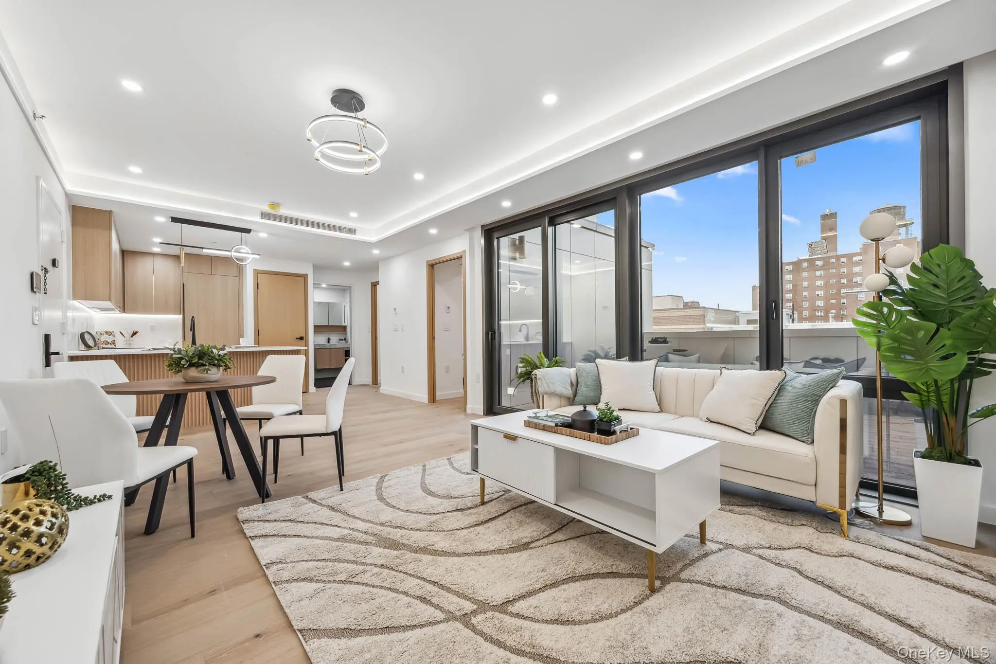 Living room with light wood-style floors, recessed lighting, baseboards, and a tray ceiling Living room with light wood-style floors, recessed lighting, baseboards, and a tray ceiling
