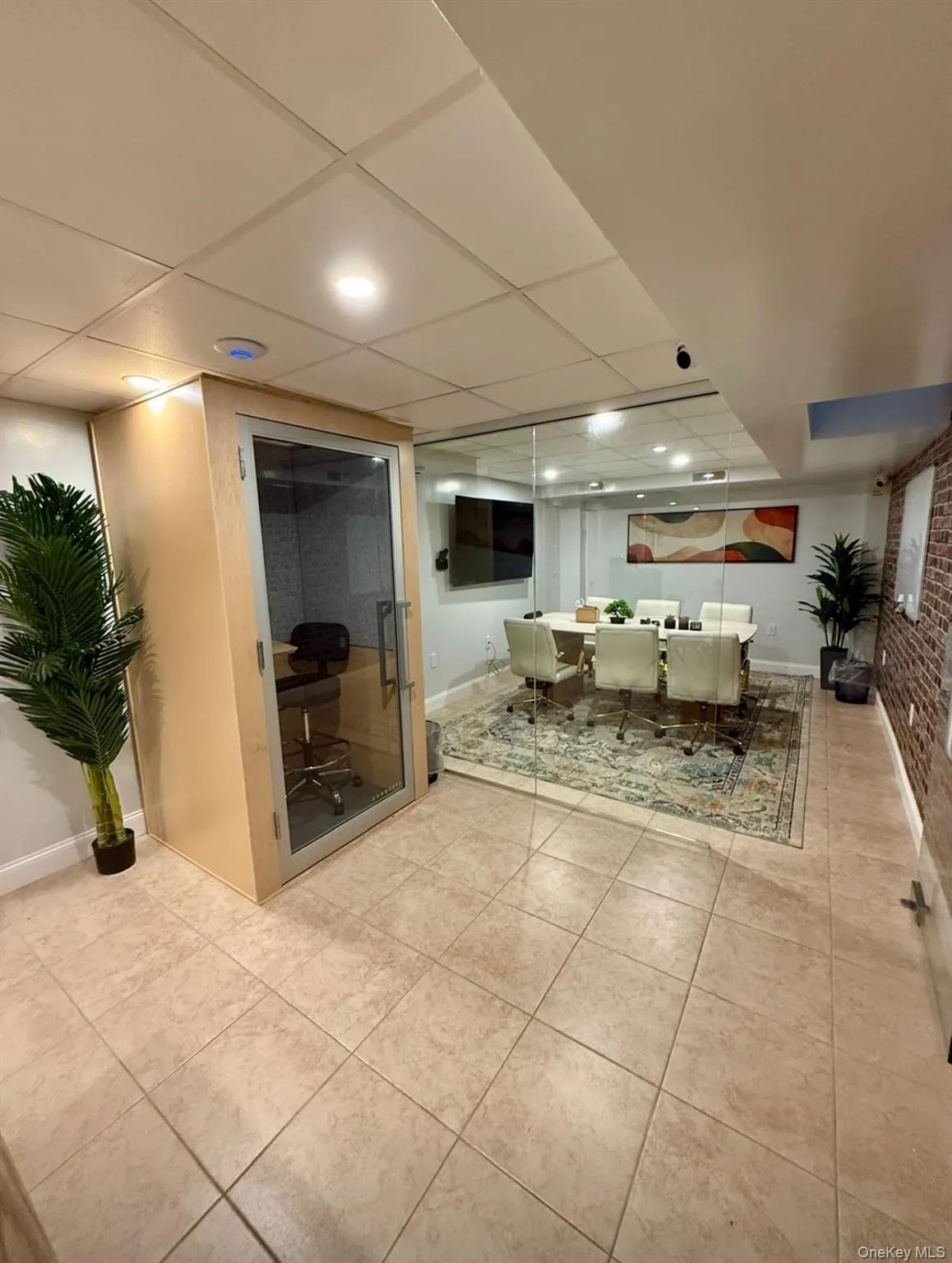 Dining area featuring light tile patterned floors and a drop ceiling Dining area featuring light tile patterned floors and a drop ceiling