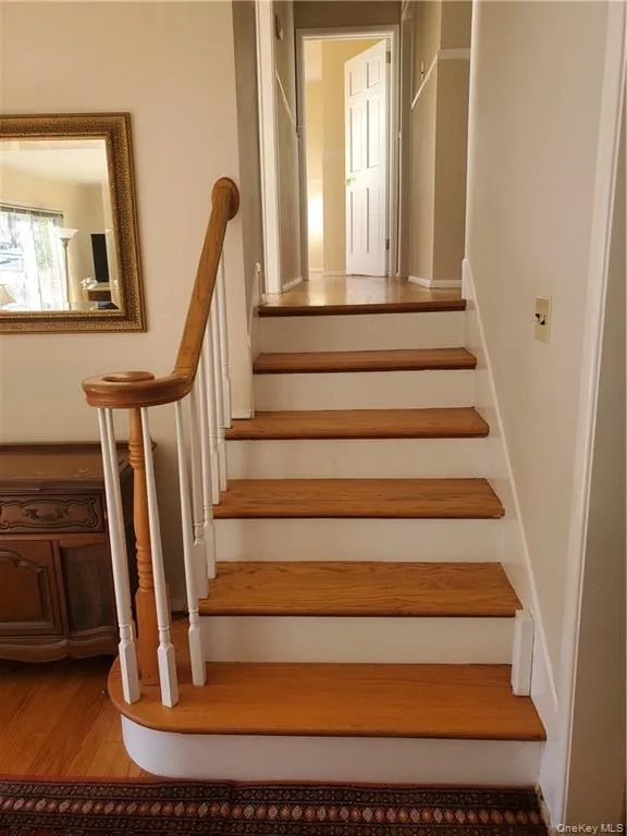 Stairs featuring wood finished floors Stairs featuring wood finished floors