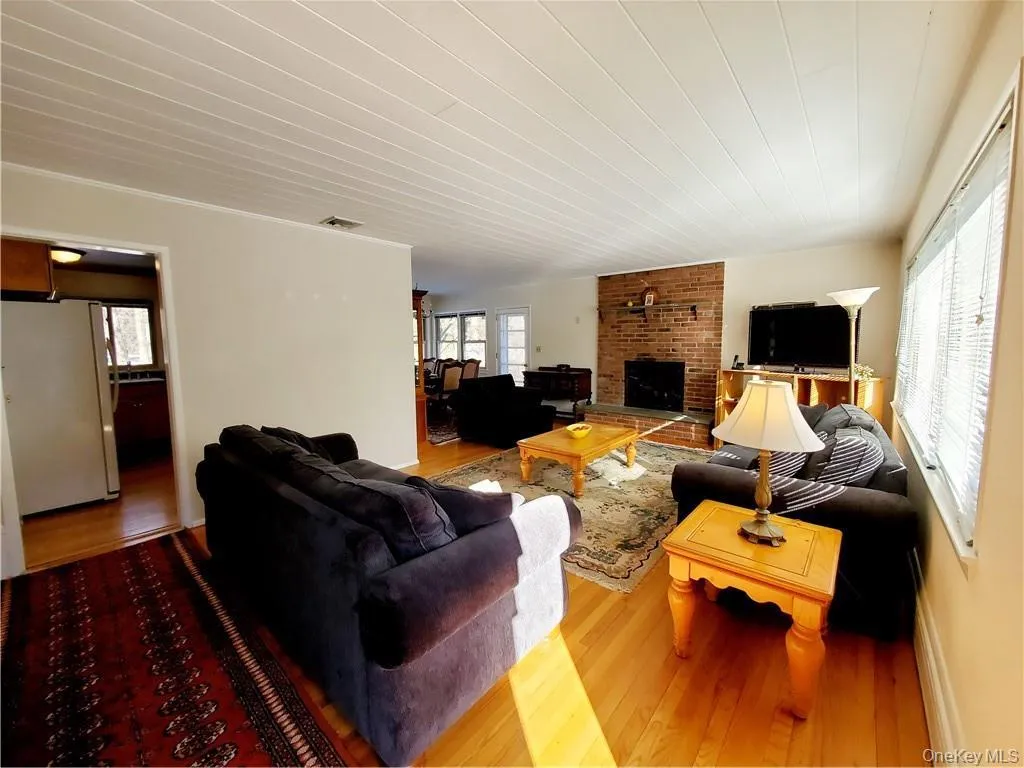 Living room featuring a fireplace, wood finished floors, and visible vents Living room featuring a fireplace, wood finished floors, and visible vents