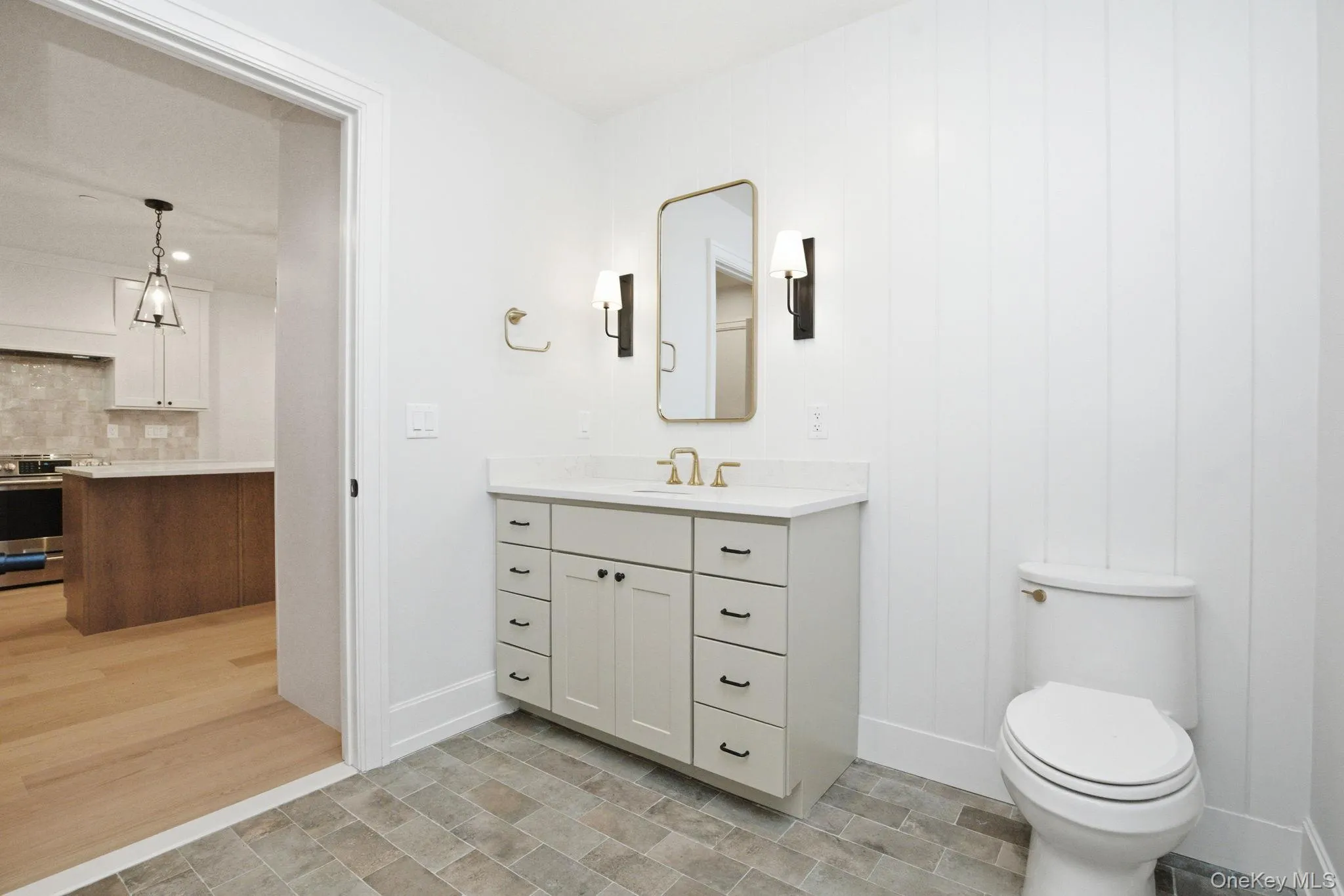 Well-appointed bathroom featuring a custom vanity with ample storage, quartz countertop, and brushed brass Kohler fixtures. Well-appointed bathroom featuring a custom vanity with ample storage, quartz countertop, and brushed brass Kohler fixtures.